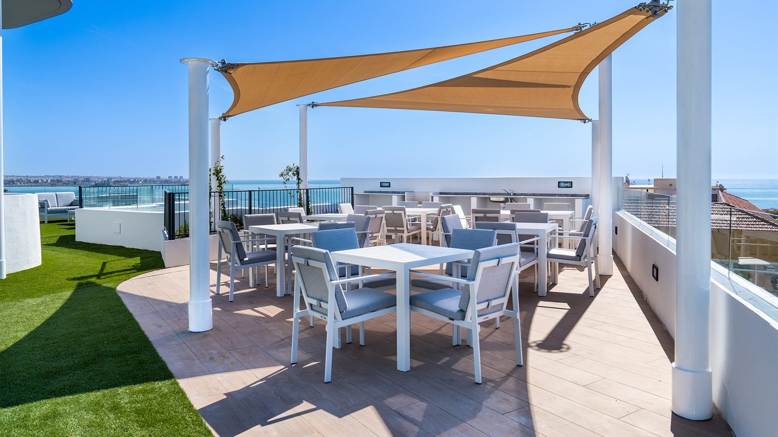 Rooftop terrace with outdoor dining, shade sails and sea views of a 3-bedroom apartment in Torrevieja - The Estates