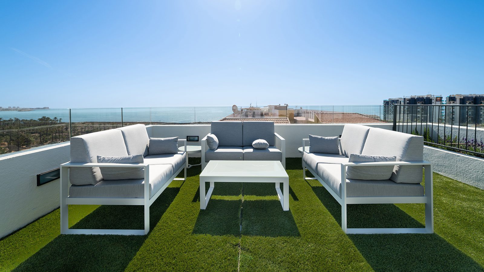 Rooftop terrace with lounge seating and panoramic sea views of a