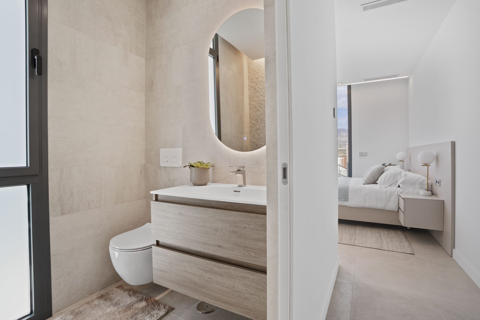A modern bathroom with a view of a bedroom in a 4-bedroom villa in Benidorm - The Estates