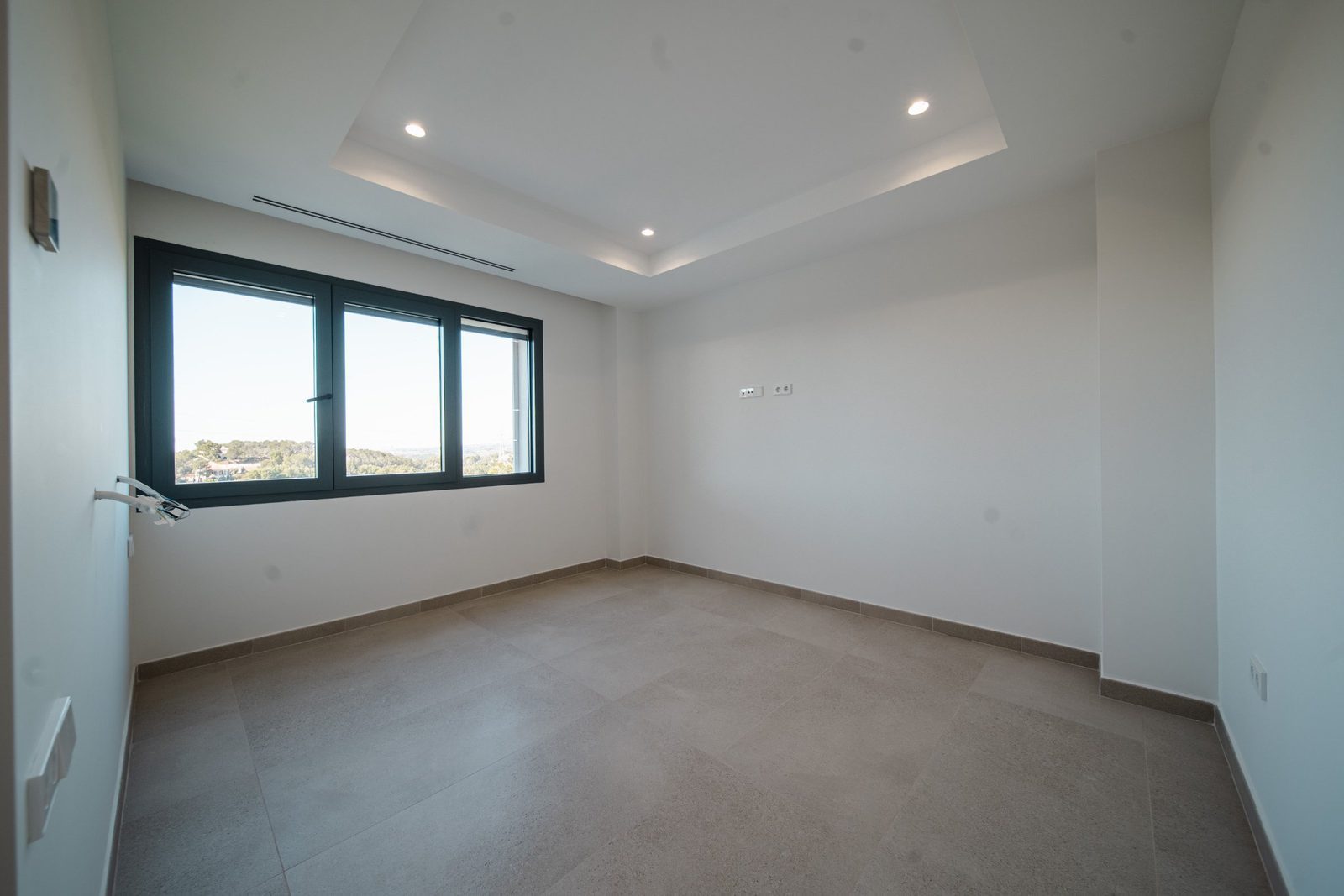 A bright, modern bedroom with large windows and tiled floors in a 5-bedroom villa in Altea - The Estates