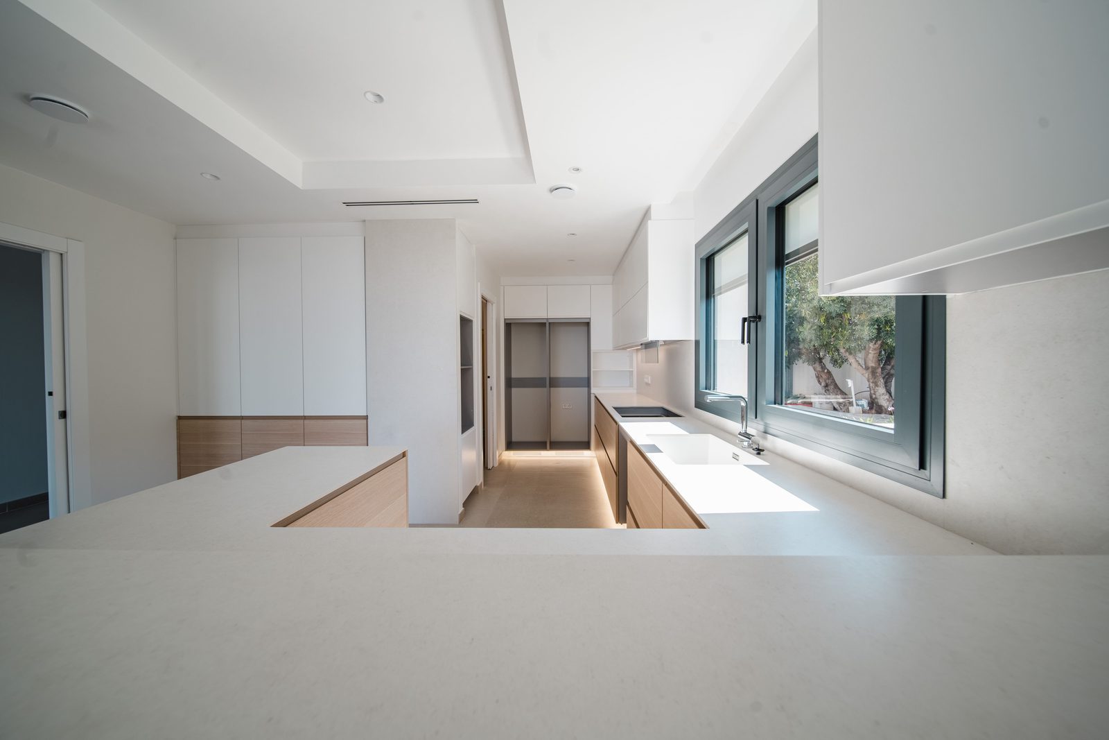 Modern kitchen with sleek cabinetry and a view from a window in a 5-bedroom villa in Altea - The Estates