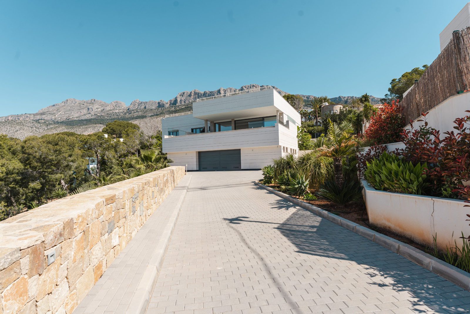 A modern villa with mountain views and a paved driveway in Altea - The Estates