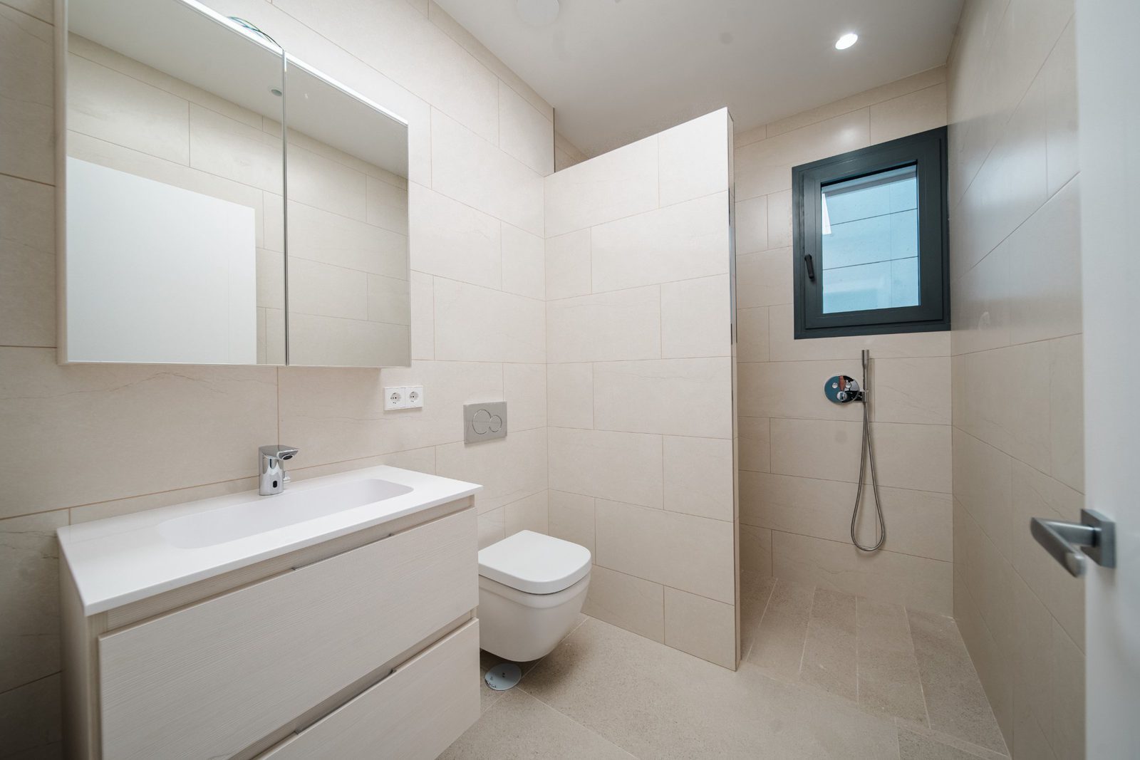 A modern bathroom with a window in a 5-bedroom villa in Altea - The Estates