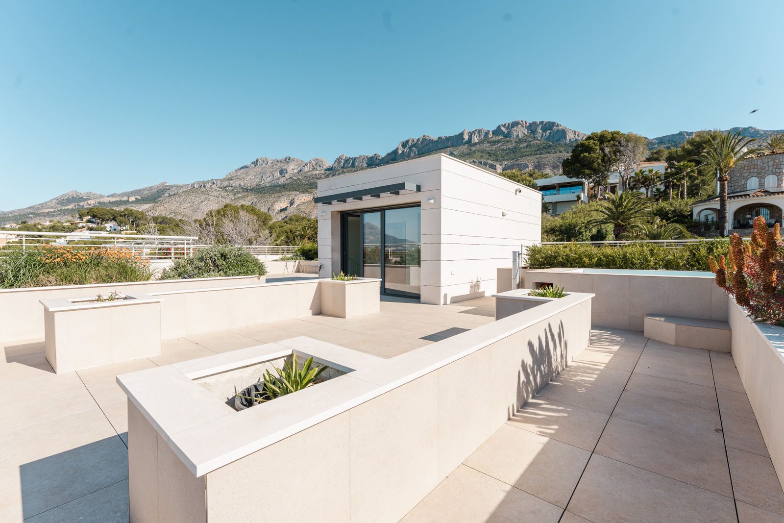 A modern rooftop terrace with a fire pit and views of the sea and mountains of a 5-bedroom villa in Altea - The Estates