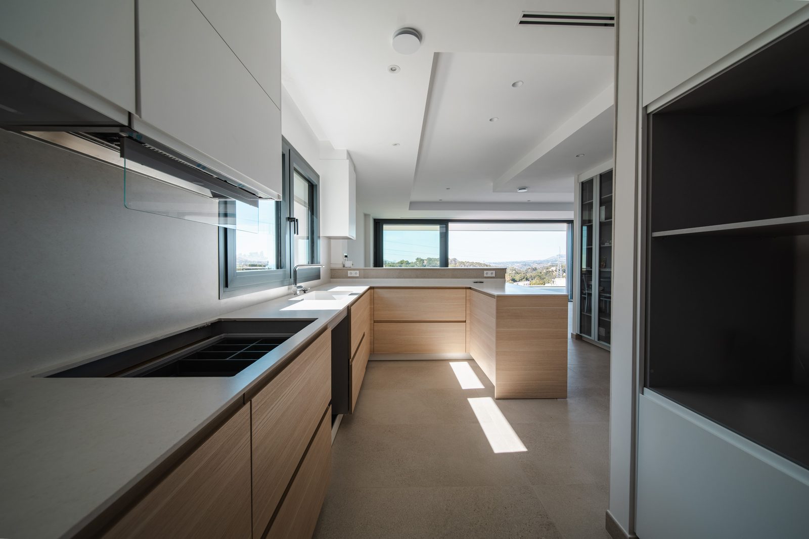 Modern kitchen with island and views of greenery in a 5-bedroom villa in Altea - The Estates