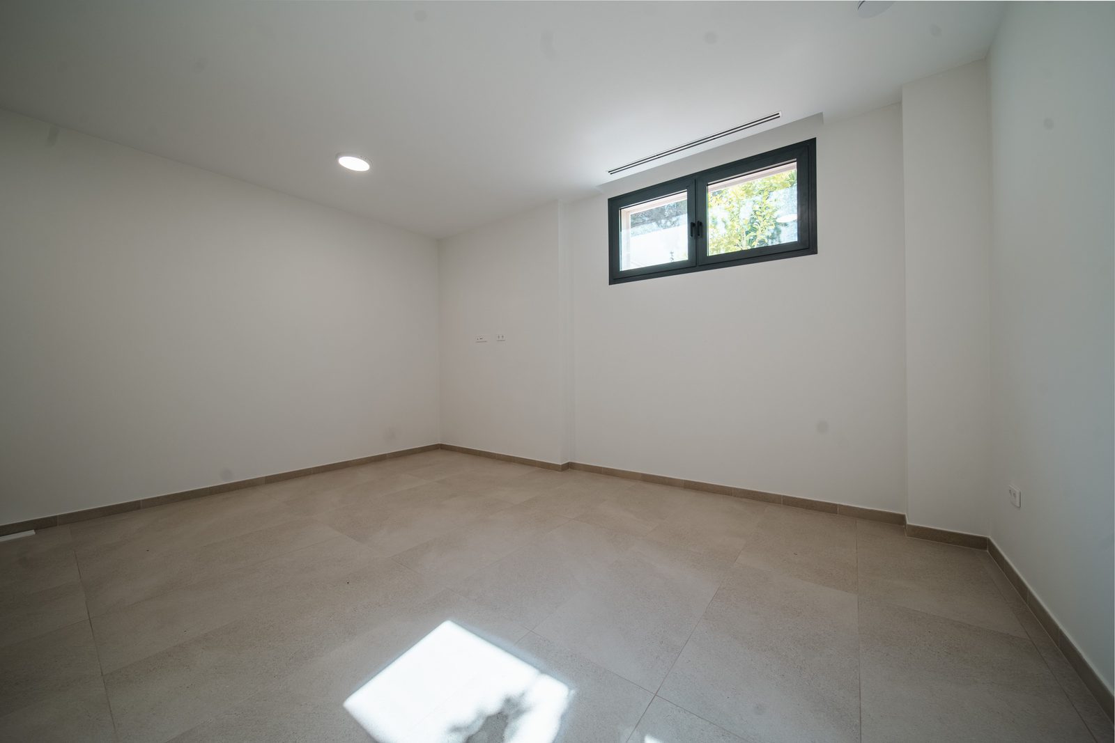 An empty, bright room with a window in a 5-bedroom villa in Altea - The Estates