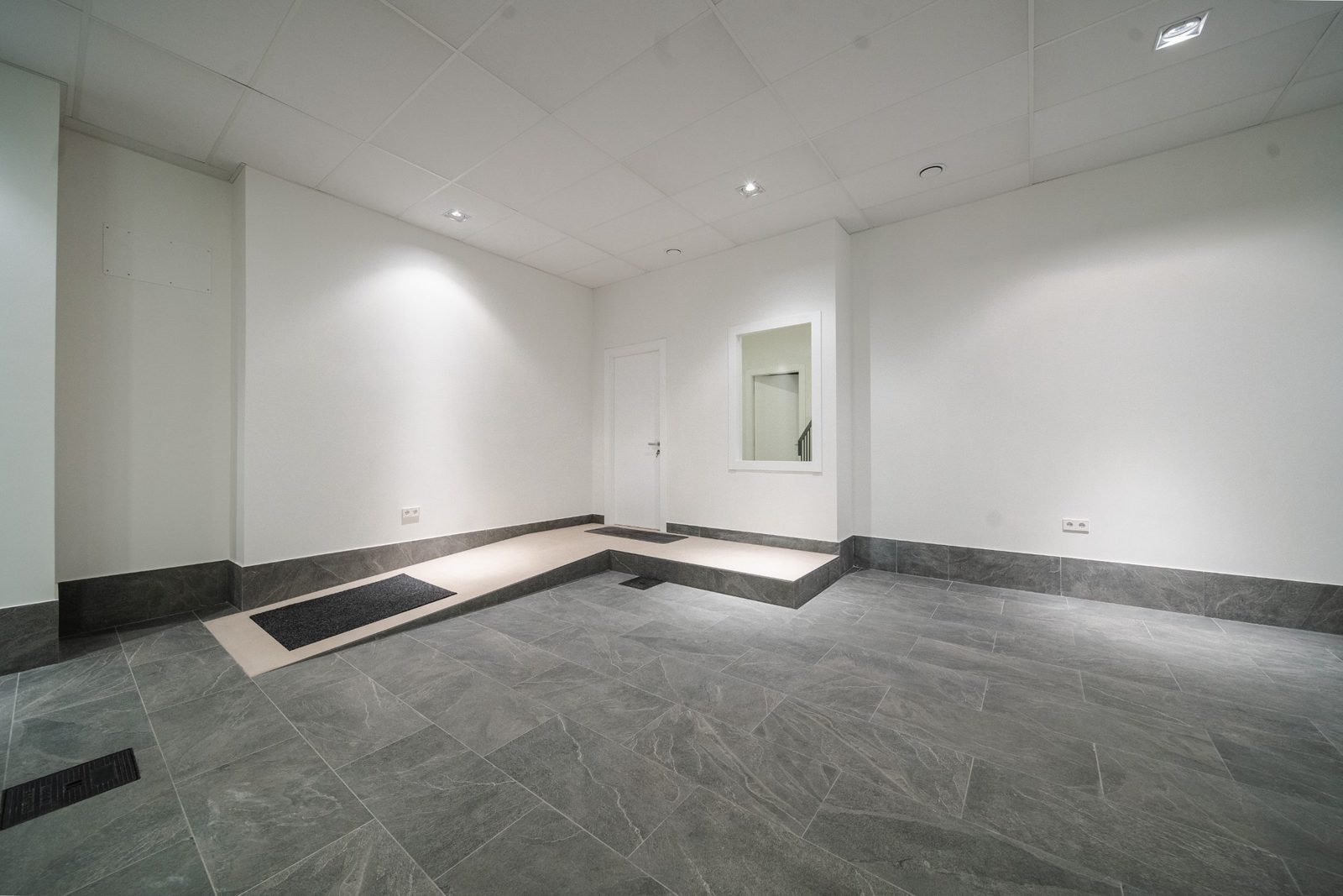 A modern hallway with tiled floors and a mirror in a 5-bedroom villa in Altea - The Estates