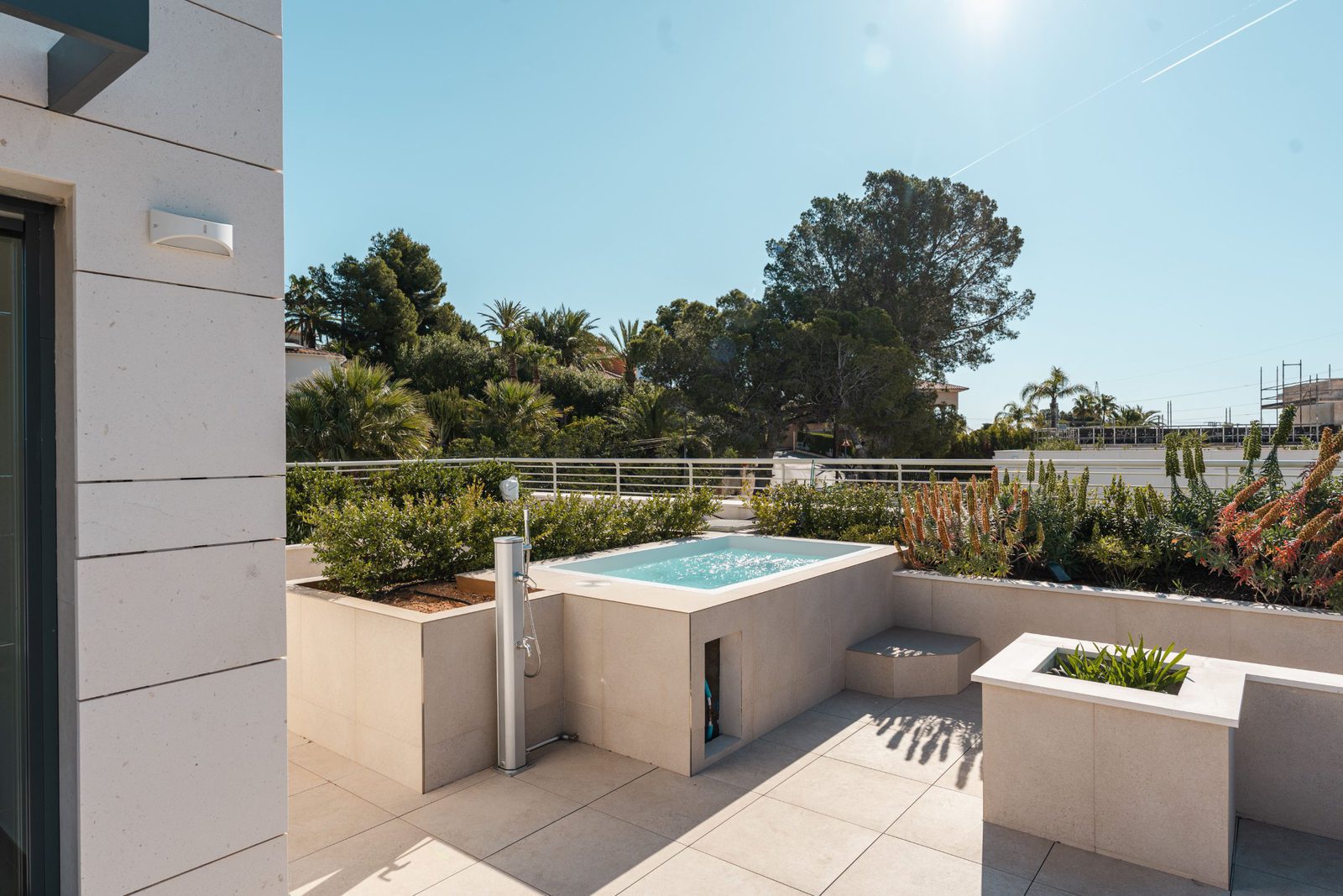 A modern rooftop terrace with a jacuzzi and lush greenery on a 5-bedroom villa in Altea - The Estates