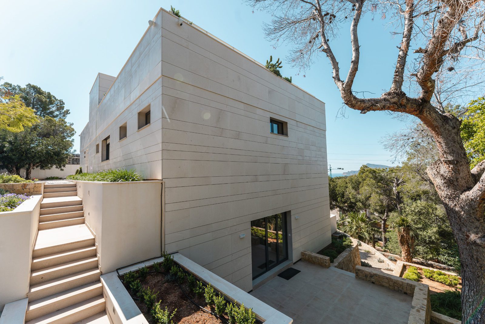 Modern exterior of a 5-bedroom villa in Altea, with steps and lush greenery - The Estates