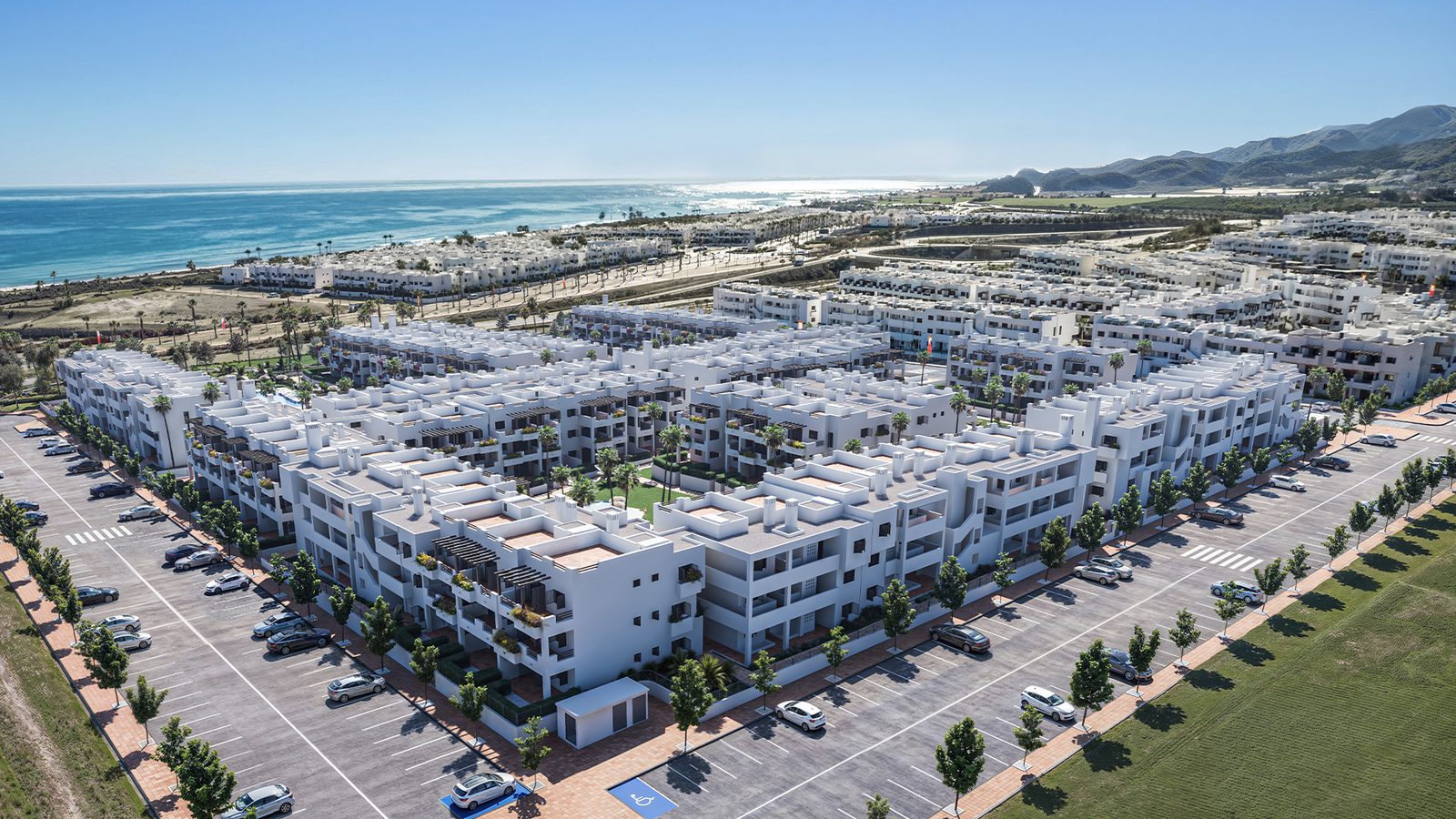 An aerial view of a white bungalow complex and coastline in Pulpí - The Estates