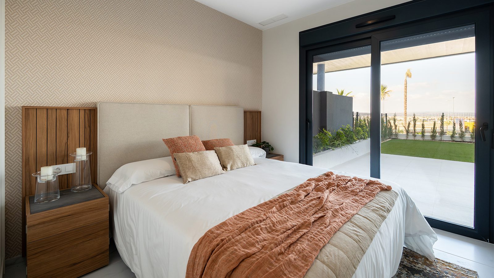 A bright bedroom with patio doors leading to a garden in a 3-bedroom bungalow in Torrevieja - The Estates