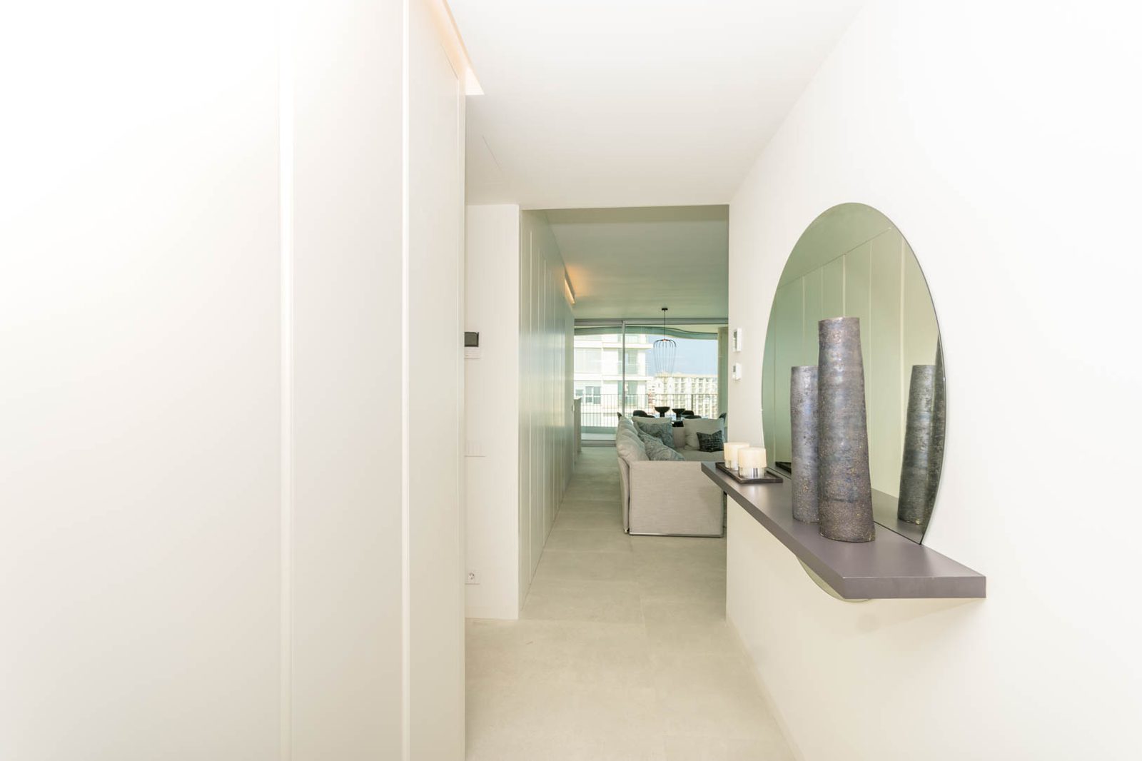 A bright hallway with a decorative mirror and glimpse of the sea in a 4-bedroom apartment in Calpe - The Estates