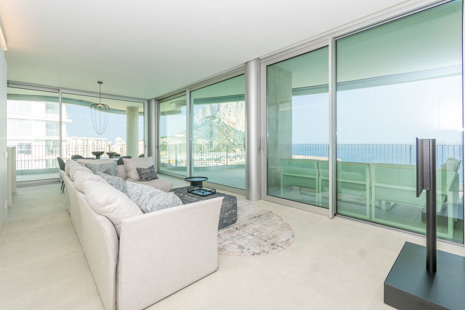 Stylish living room with panoramic sea and mountain views of a 4-bedroom apartment in Calpe - The Estates