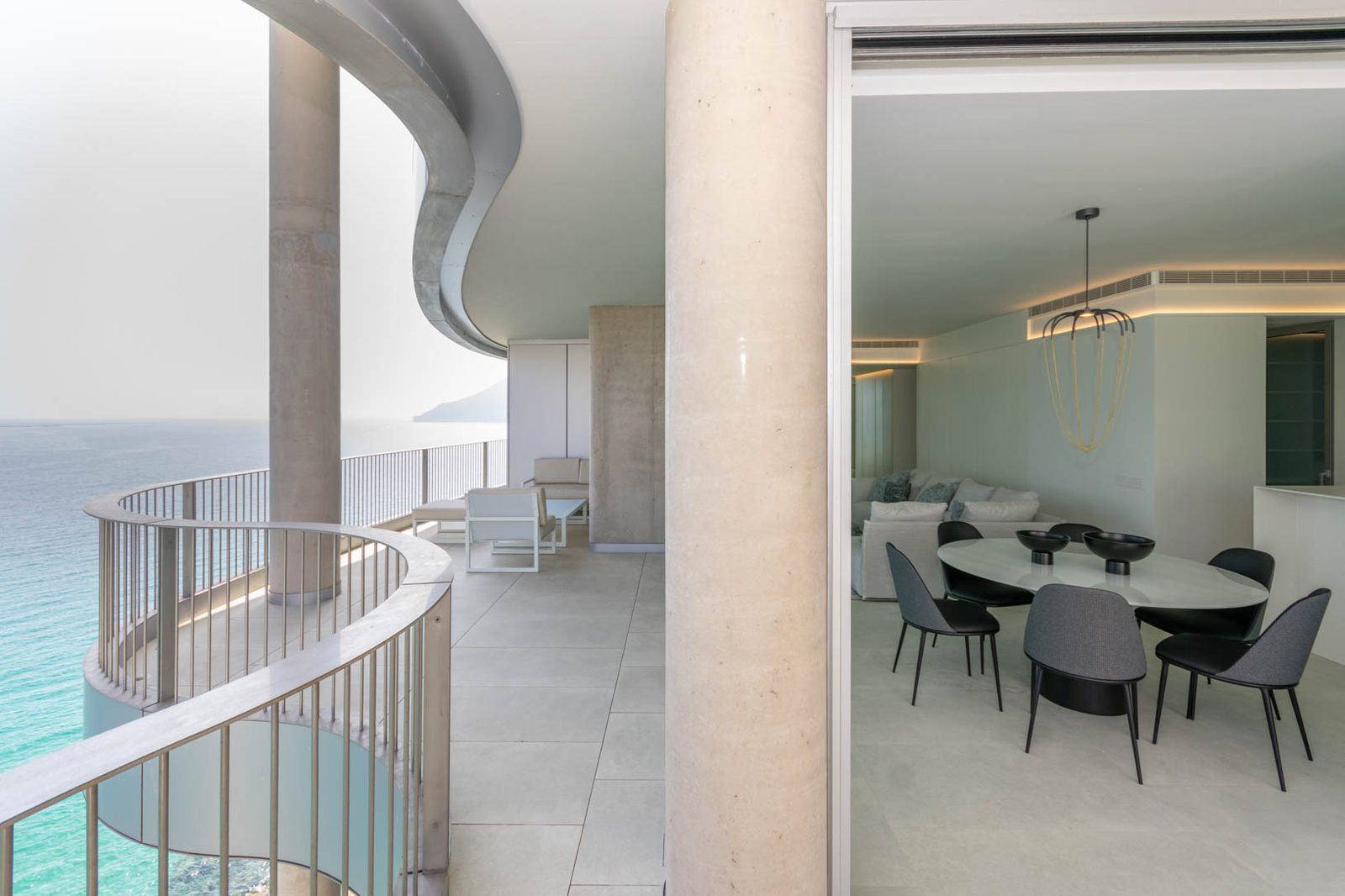 Stylish living and dining area with a balcony overlooking the sea in a 4-bedroom apartment in Calpe - The Estates