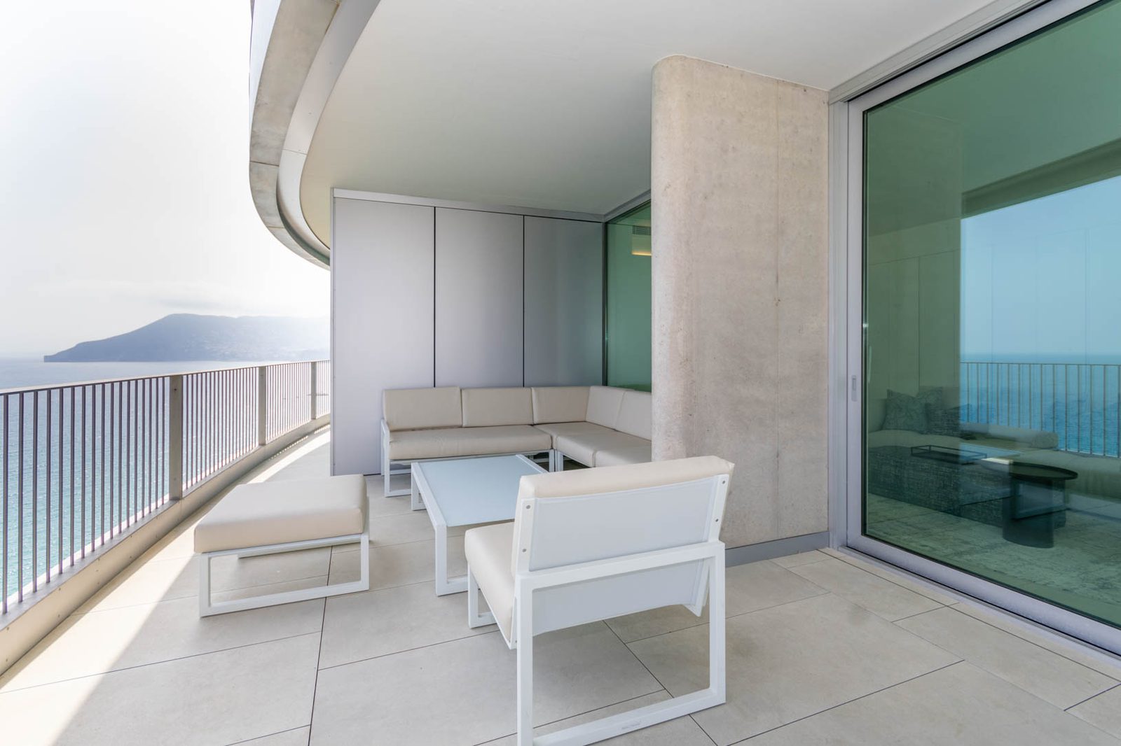 A spacious terrace with seating overlooking the sea and mountains of a 4-bedroom apartment in Calpe - The Estates