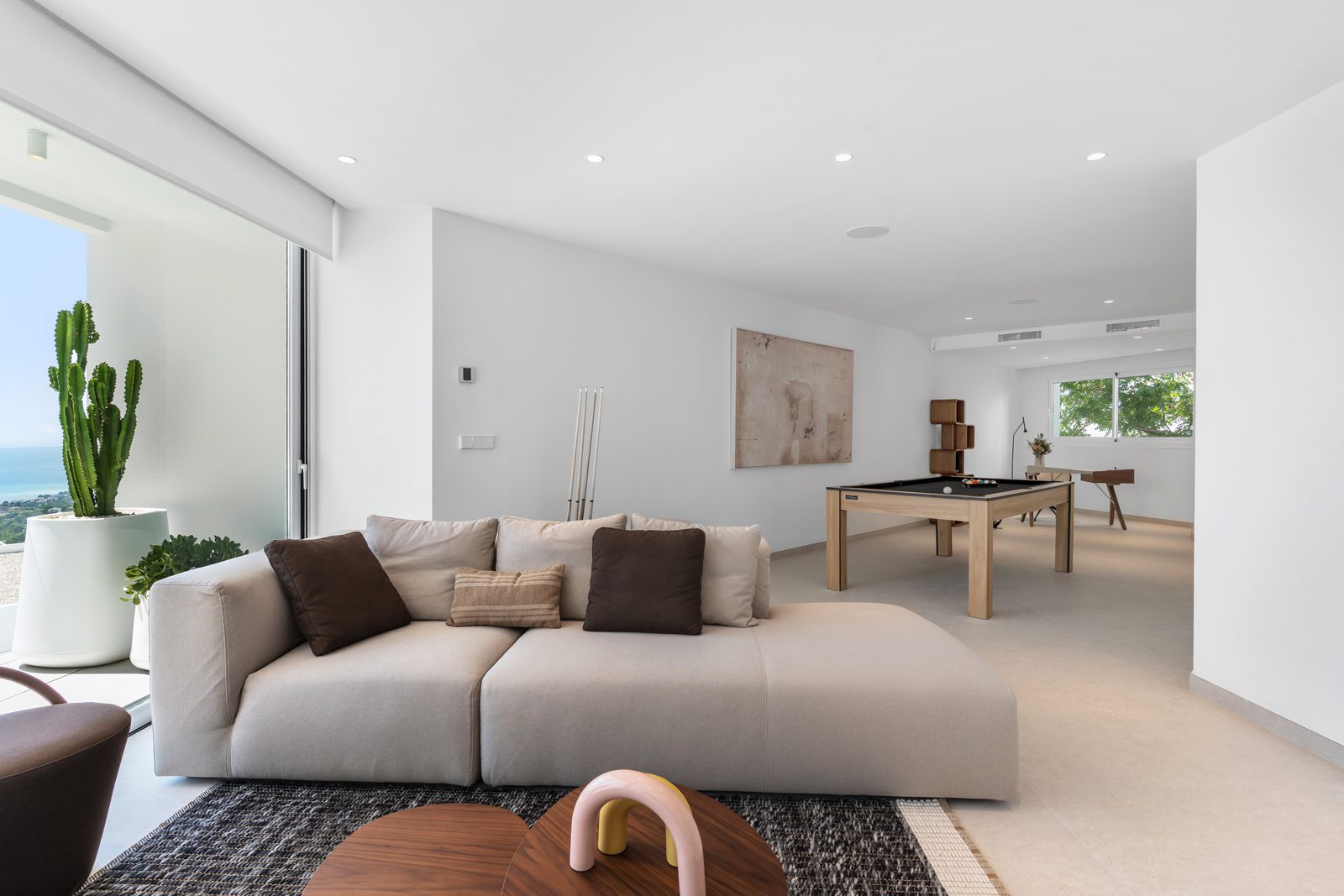 A stylish living room with a pool table and comfortable seating in a 4-bedroom villa in Altea - The Estates