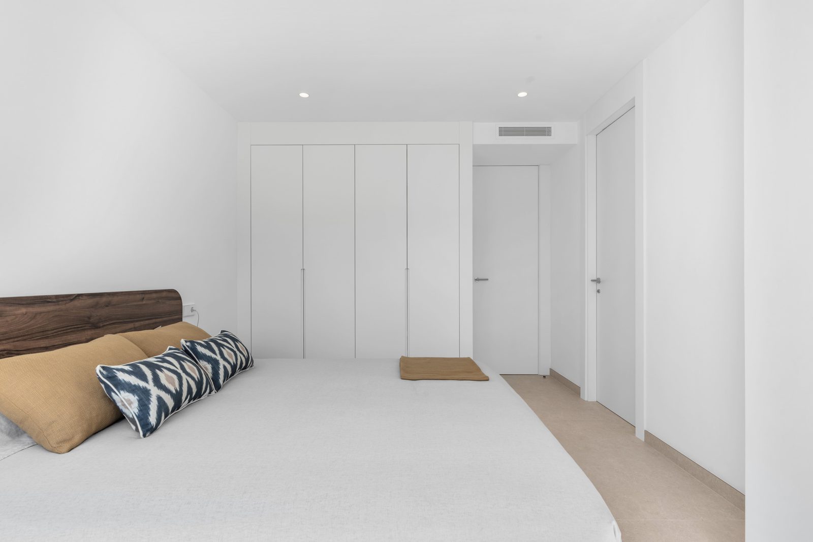 A modern bedroom with built-in wardrobes and stylish decor in a 4-bedroom villa in Altea - The Estates