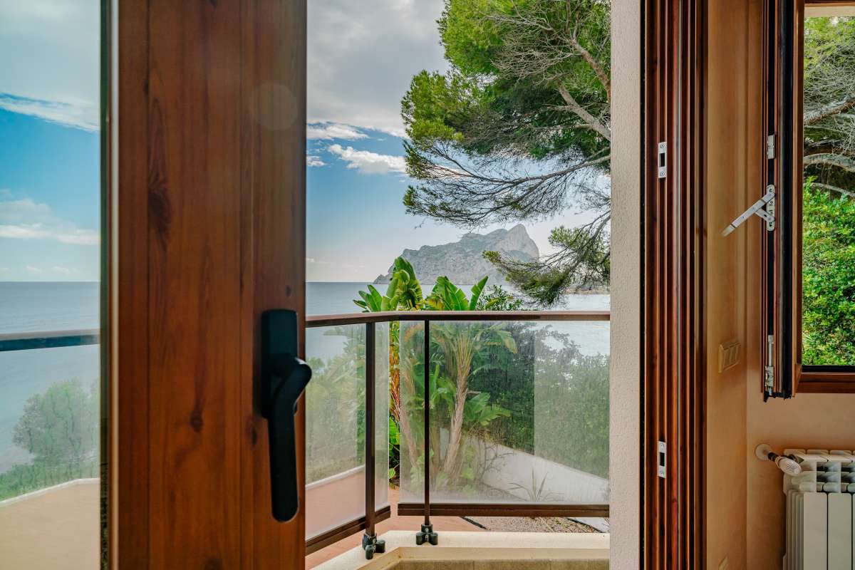 Open window framing a sea view and lush greenery from a 6-bedroom villa in Calpe - The Estates
