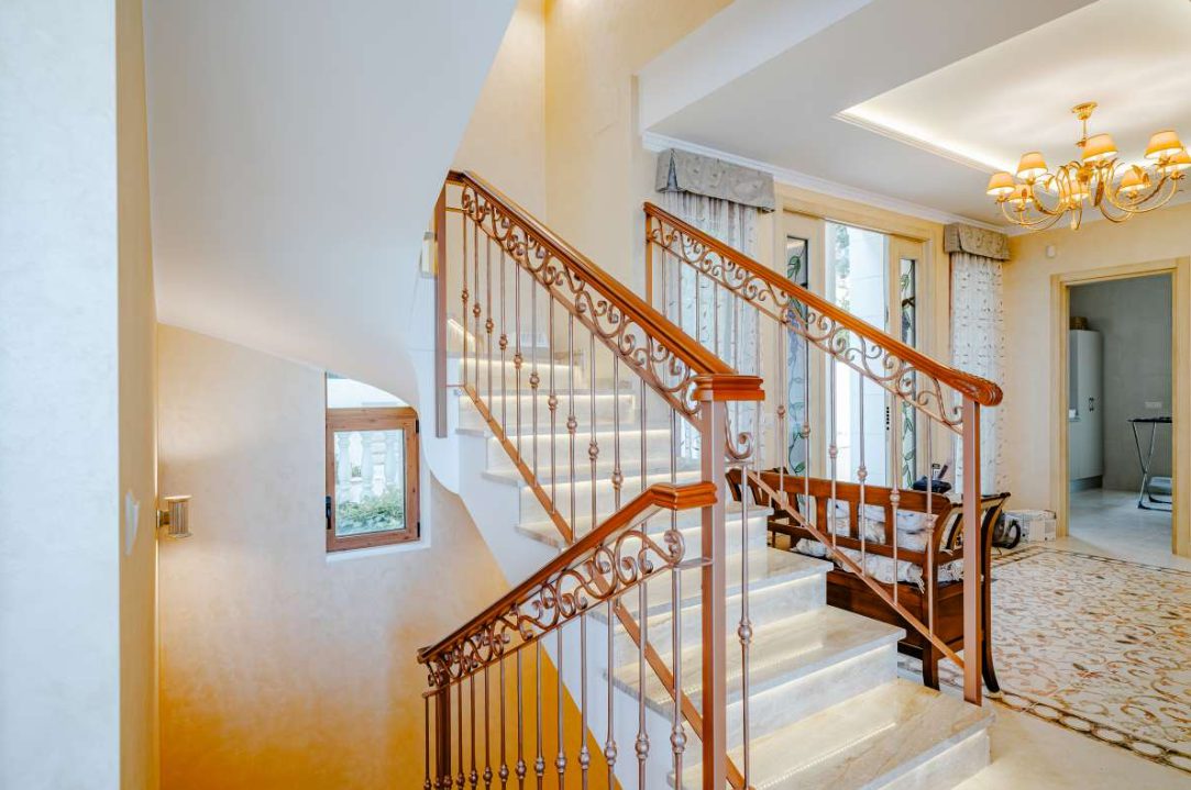 Elegant staircase with wrought iron railings inside a 6-bedroom villa in Calpe - The Estates