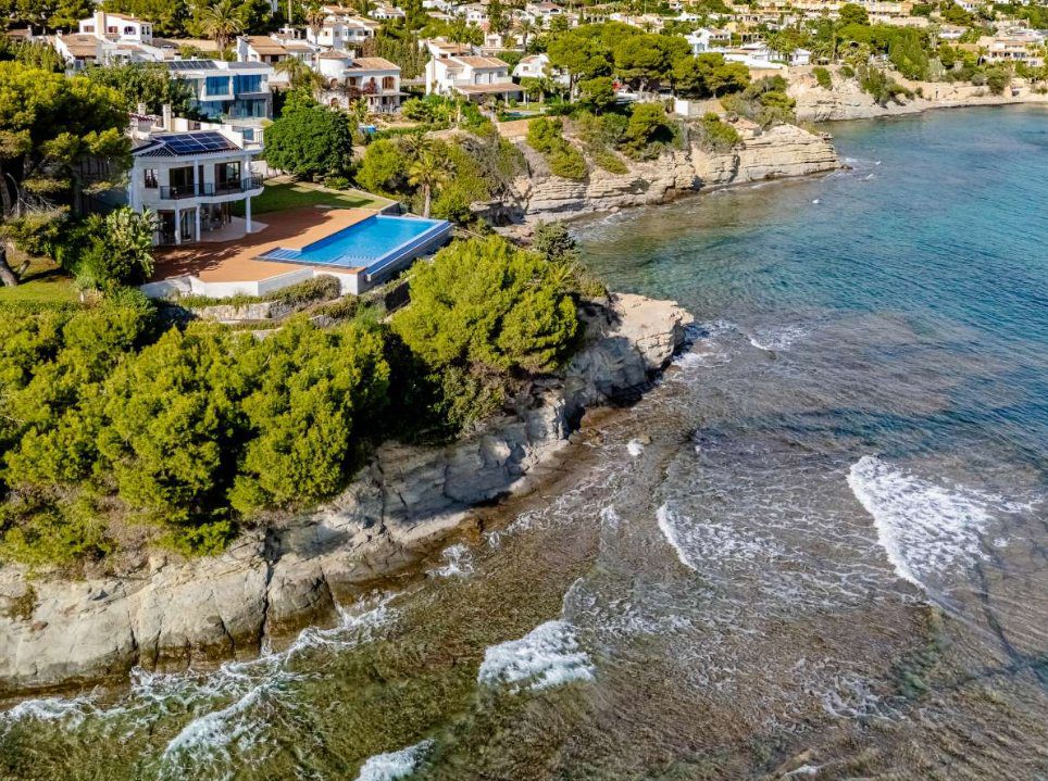 An aerial view of a stunning villa with a pool and coastal views in Calpe - The Estates