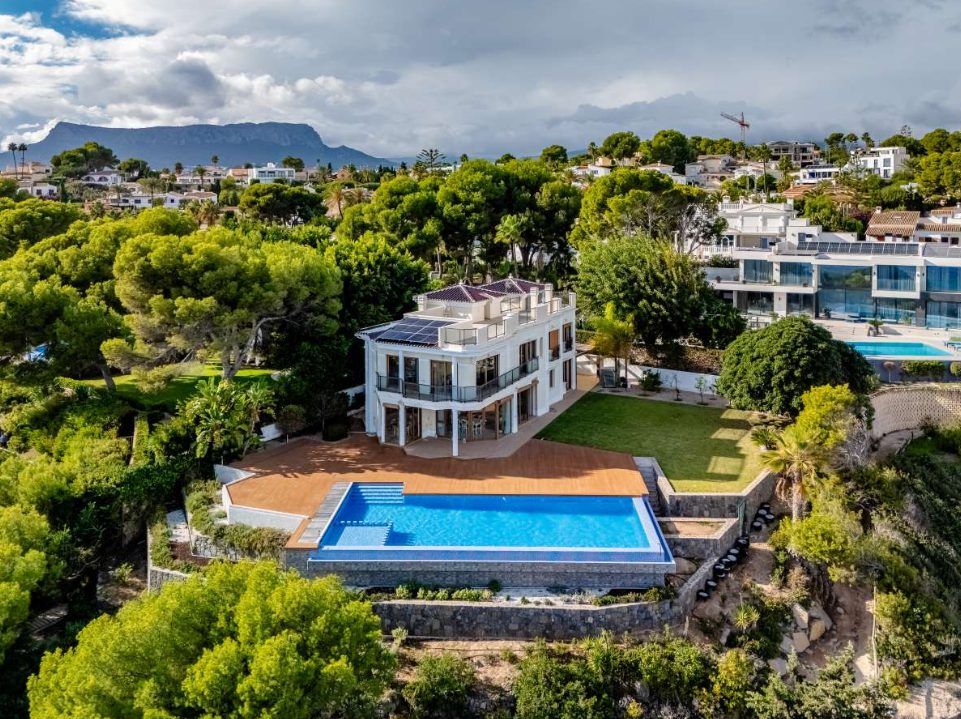 An aerial view of a luxurious villa with a pool and stunning sea views in Calpe - The Estates
