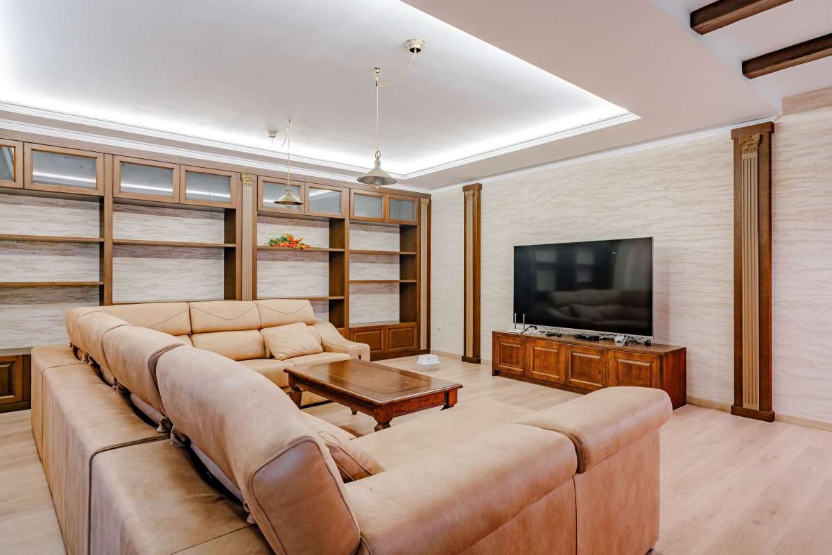 A modern living room with a large sectional sofa and TV in a 6-bedroom villa in Calpe - The Estates