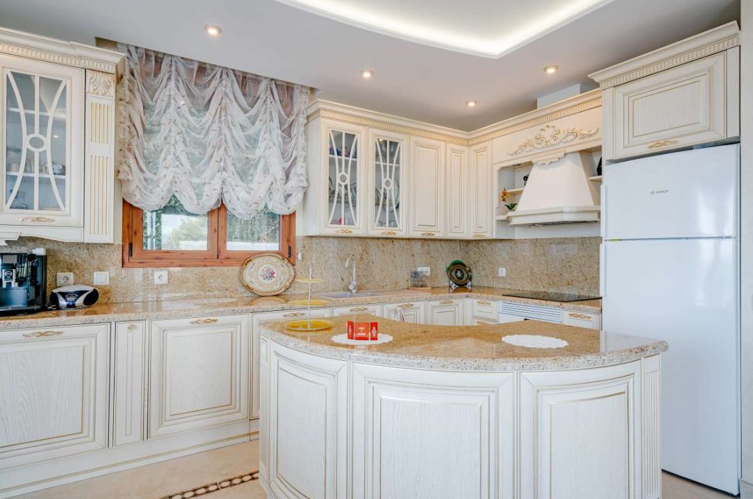 Elegant kitchen with island and views of the garden in a 6-bedroom villa in Calpe - The Estates