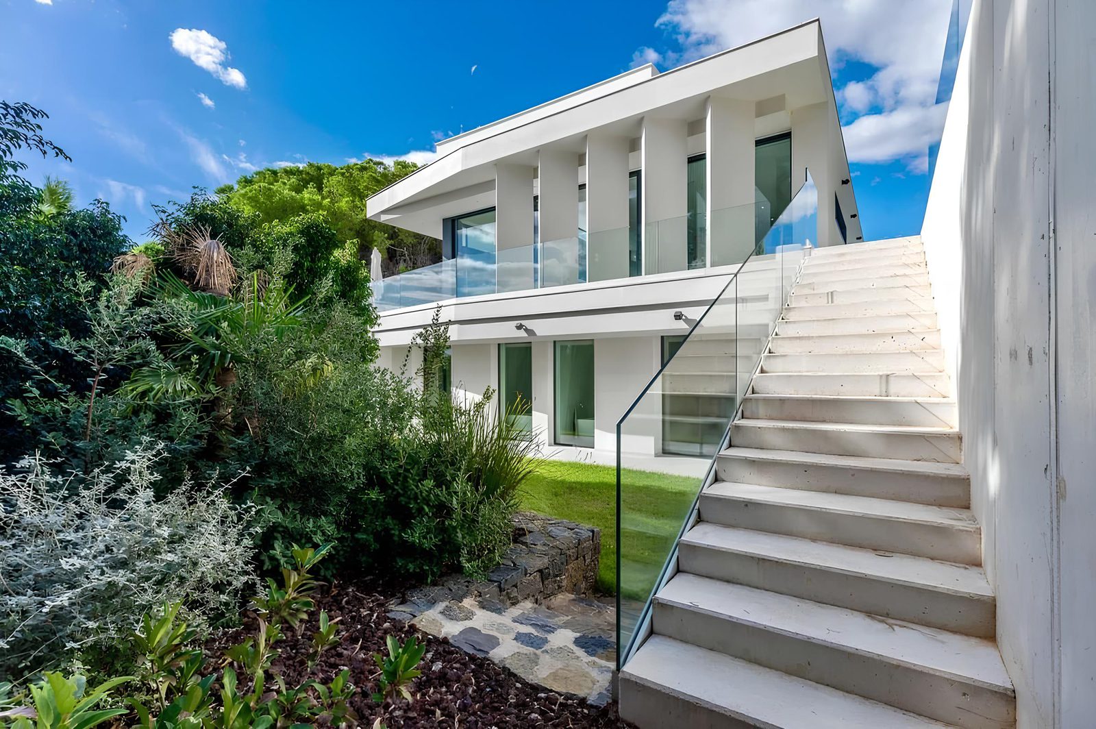 Exterior view of a modern 7-bedroom villa with steps and lush greenery in Altea - The Estates