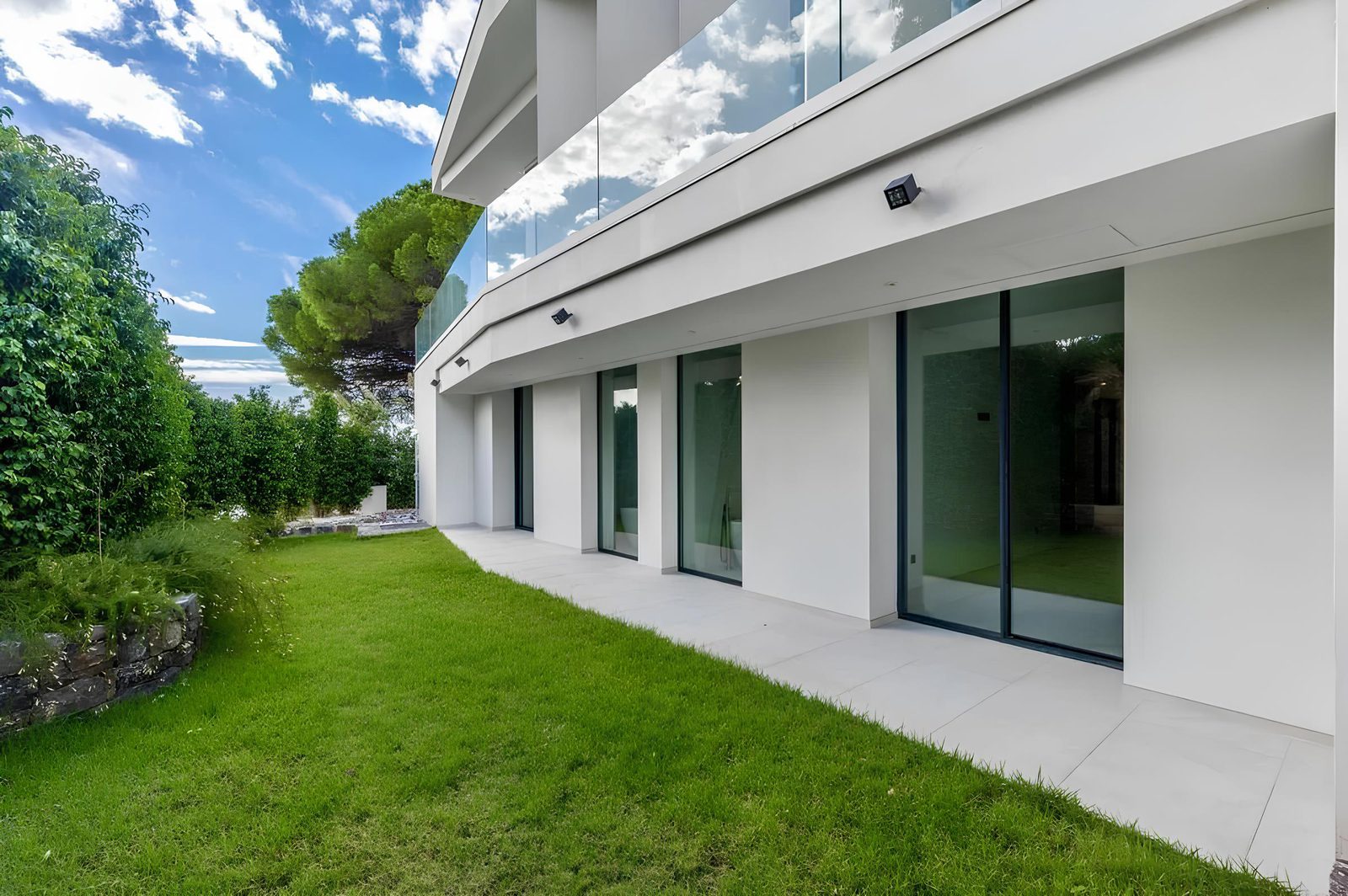 Modern exterior of a 7-bedroom villa with a lush lawn and sea views in Altea - The Estates