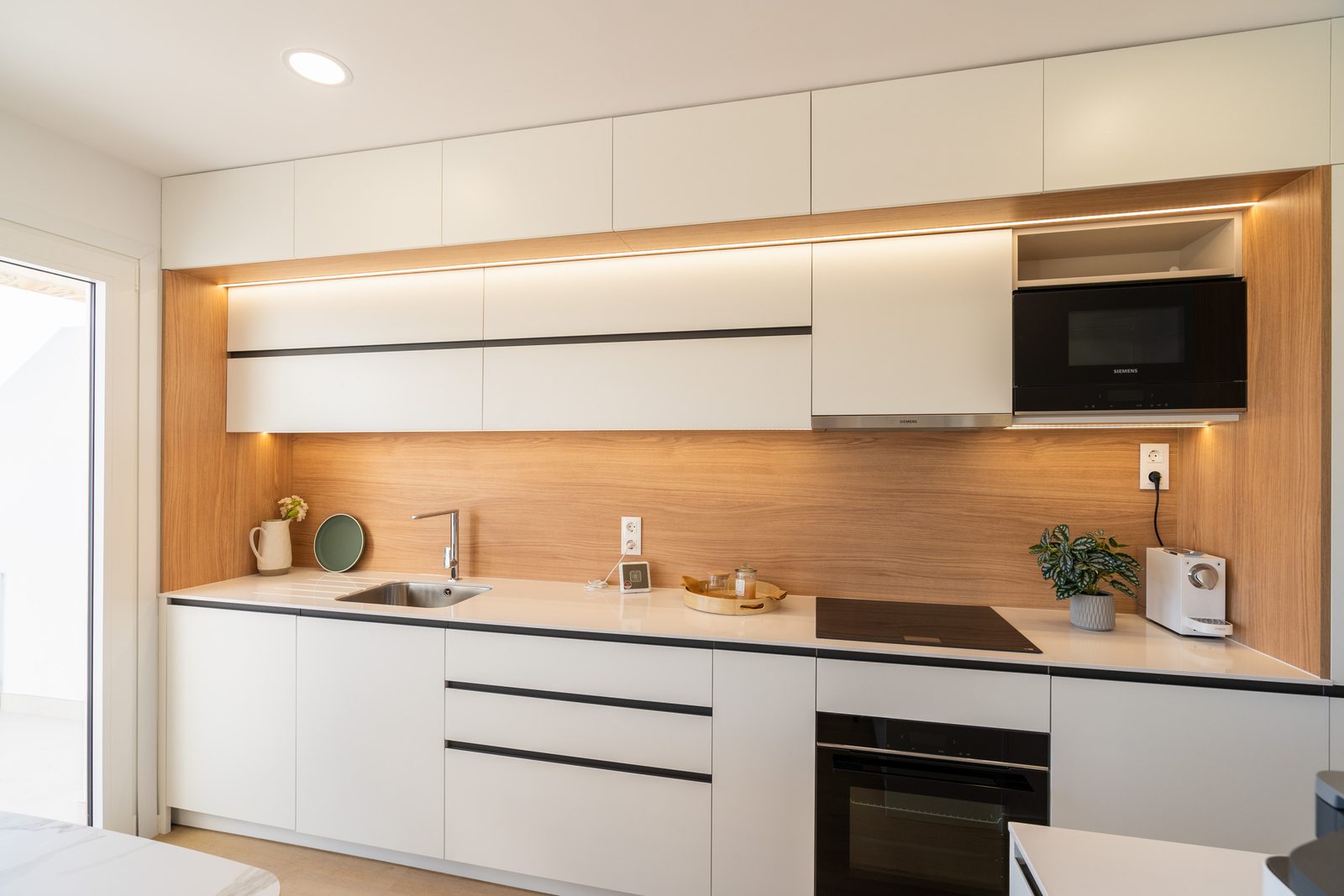 A modern kitchen with sleek cabinetry and appliances in a 4-bedroom townhouse in La Nucía - The Estates