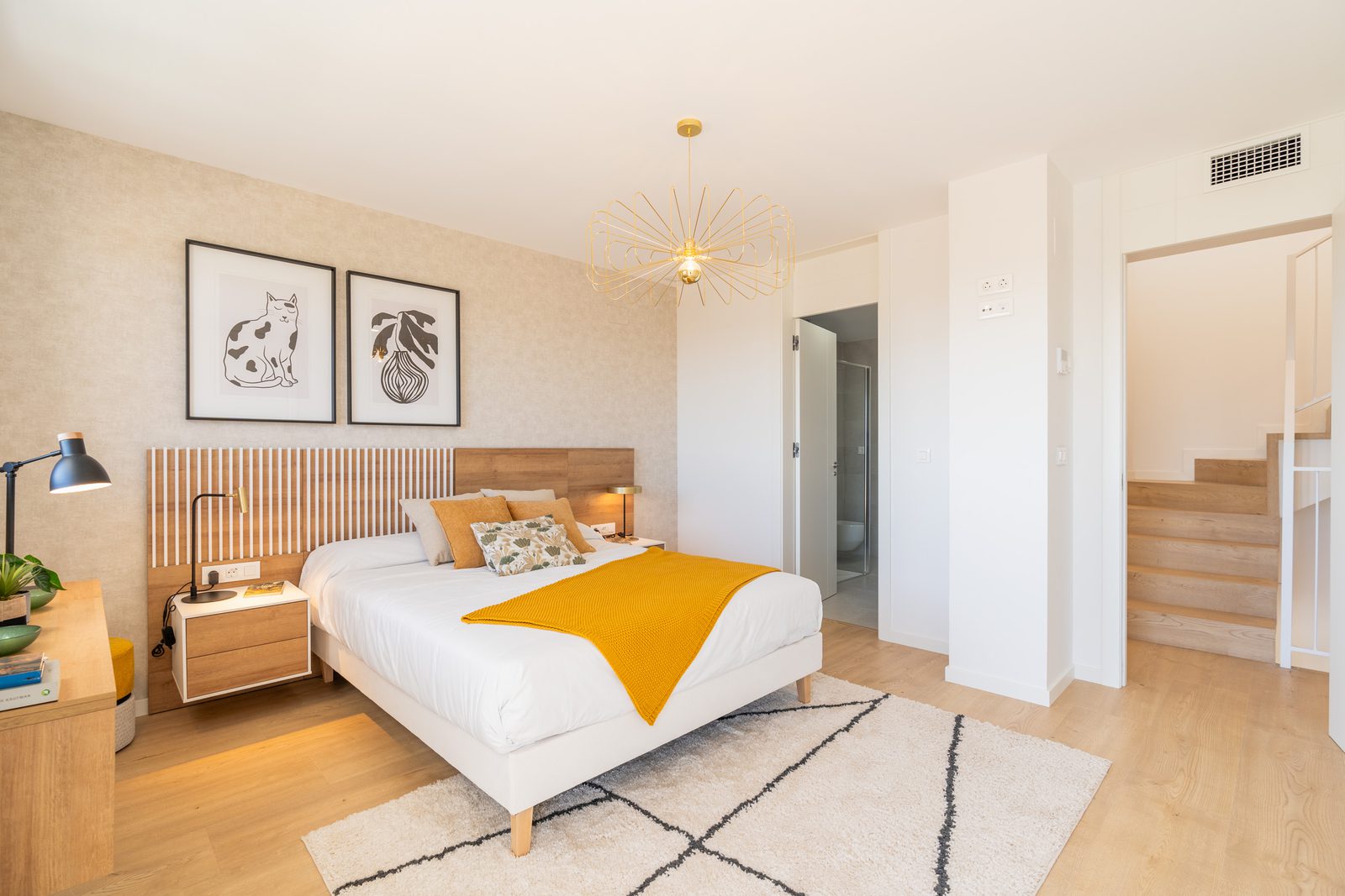 A stylish bedroom with artwork and a modern light fixture in a 4-bedroom townhouse in La Nucía - The Estates