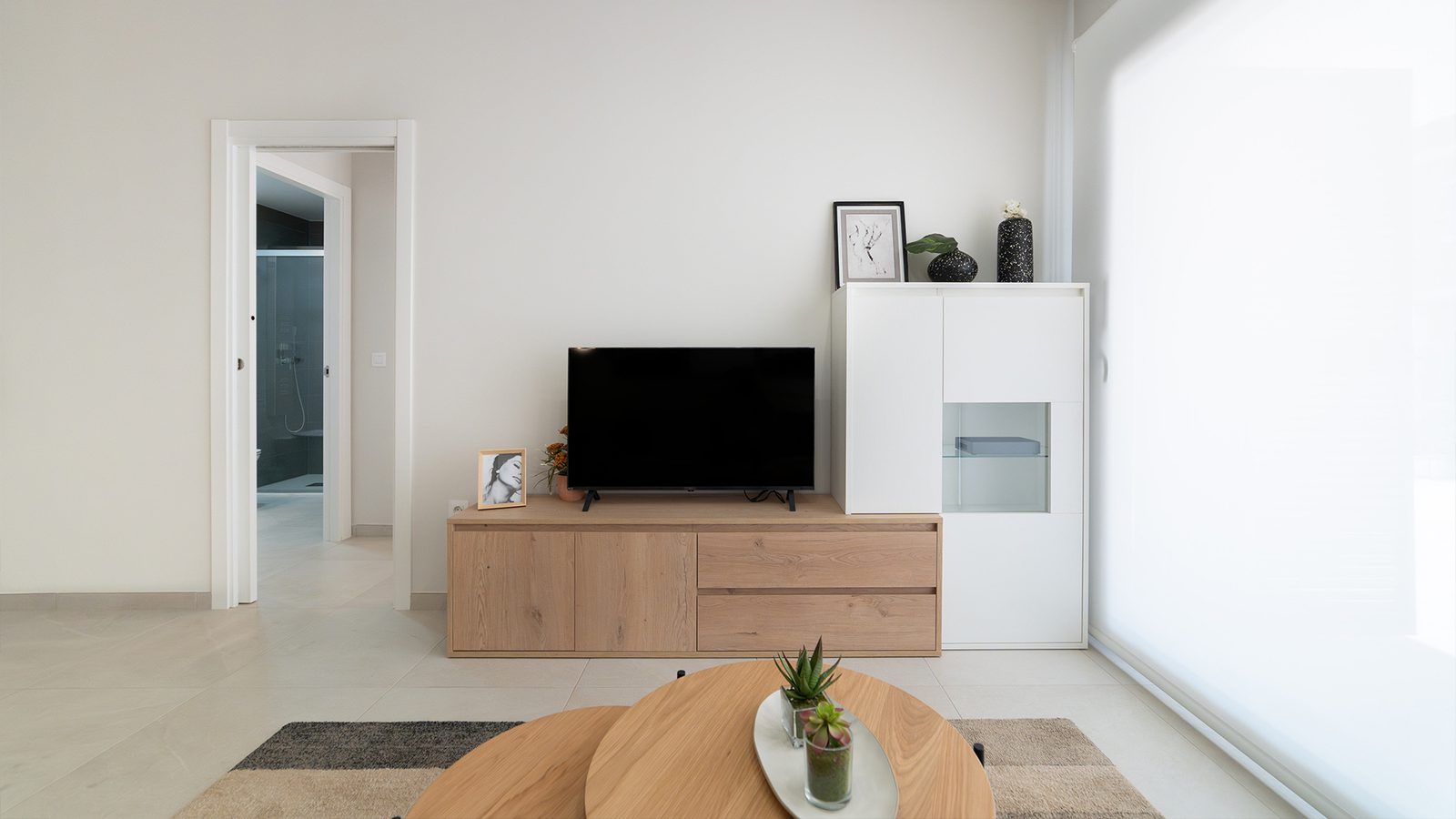 A modern living room with a TV and stylish furniture in a 2-bedroom bungalow in Pulpí - The Estates