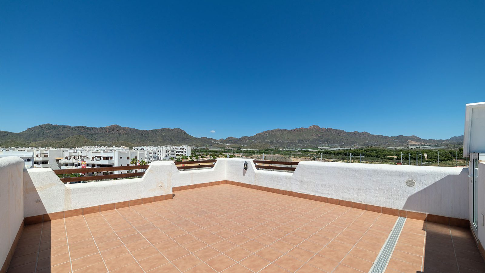 A rooftop terrace overlooking a town and mountains near a 1-bedroom bungalow in Pulpí - The Estates
