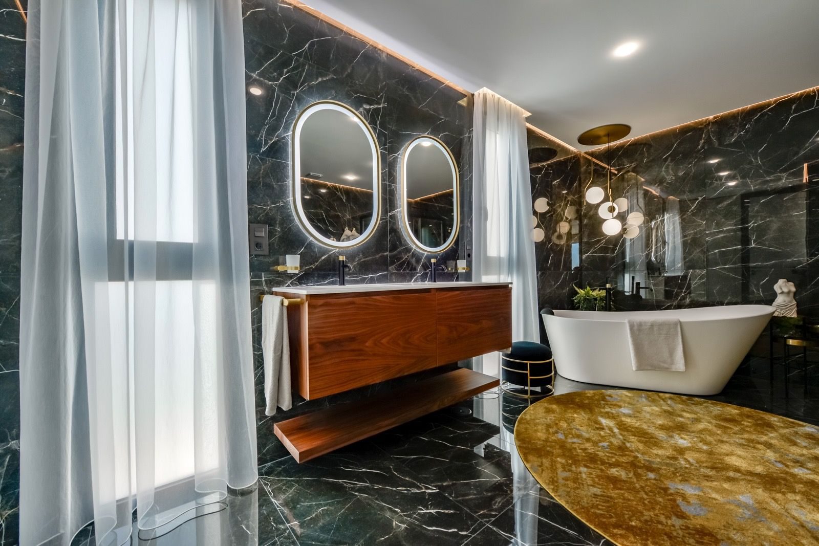 Luxurious bathroom with marble walls, a modern vanity, and a freestanding tub in a 7-bedroom villa in Finestrat - The Estates