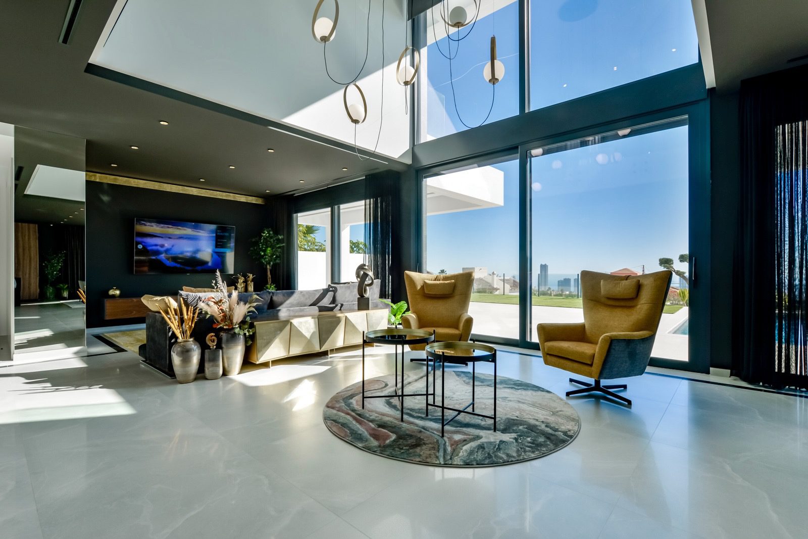 Stylish living room with expansive windows and sea views in a 7-bedroom villa in Finestrat - The Estates