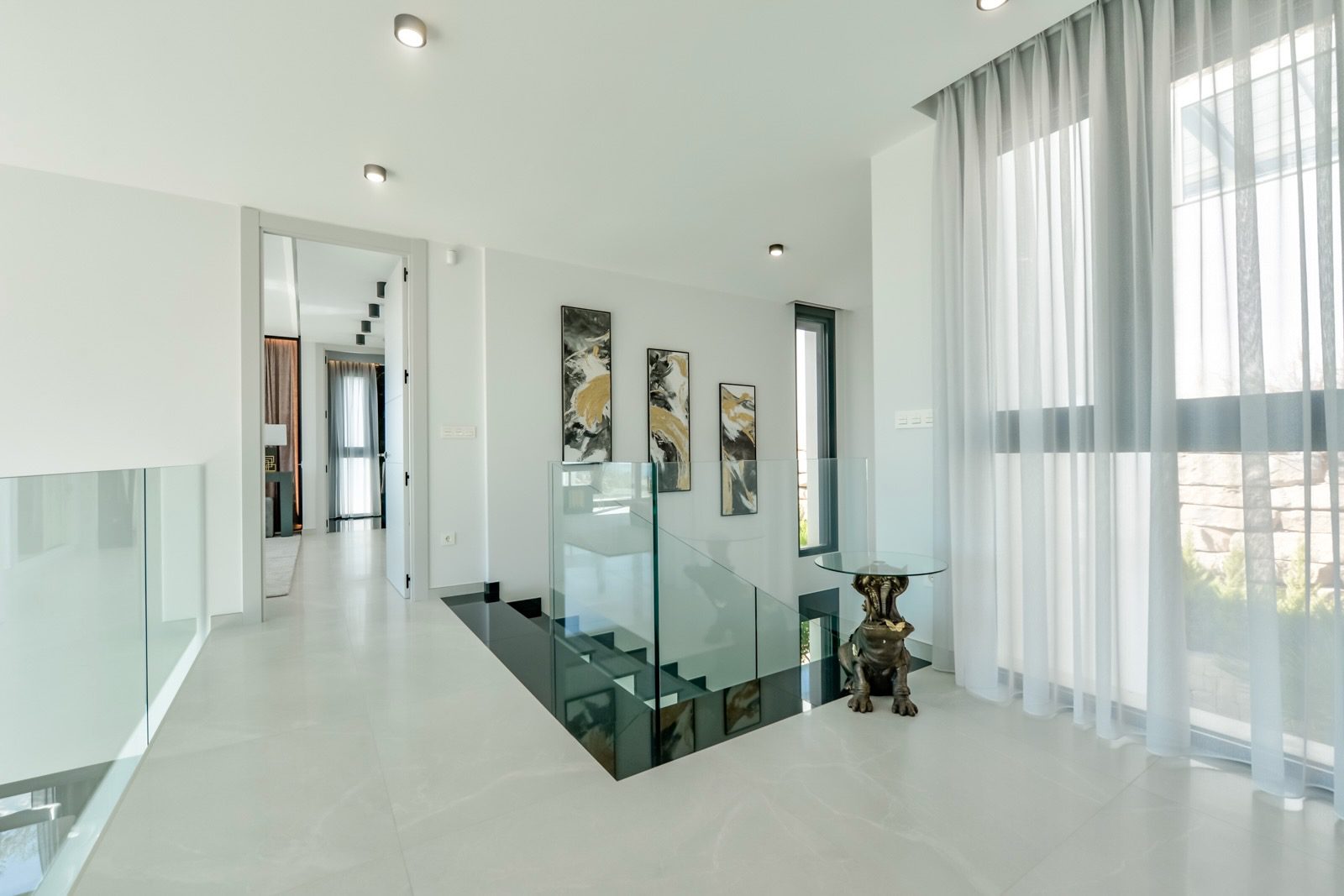 Elegant interior hallway with glass railings and large windows in a 7-bedroom villa in Finestrat - The Estates