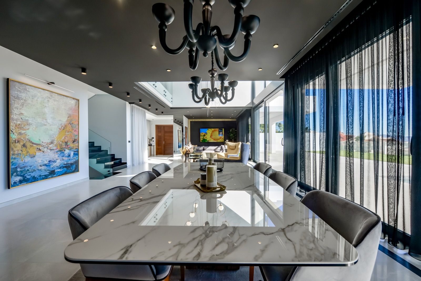 Elegant dining room with a marble table and modern chandelier in a 7-bedroom villa in Finestrat - The Estates