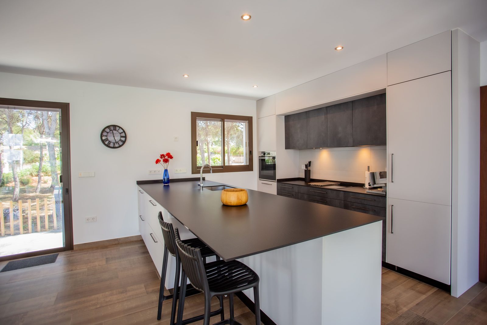 A modern kitchen with island seating in a 3-bedroom villa in Javea - The Estates