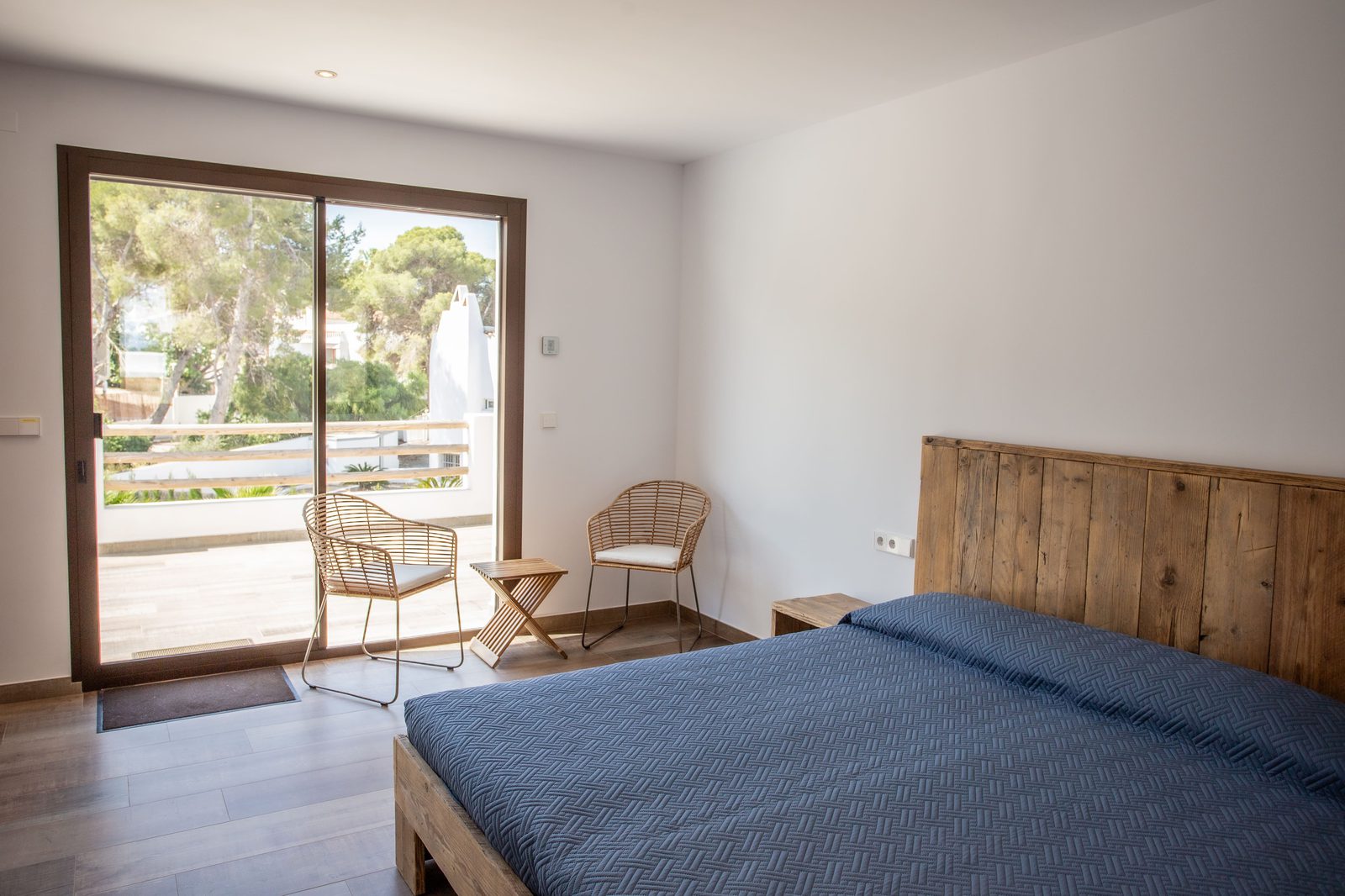 A bright bedroom with patio doors and garden views in a 3-bedroom villa in Javea - The Estates