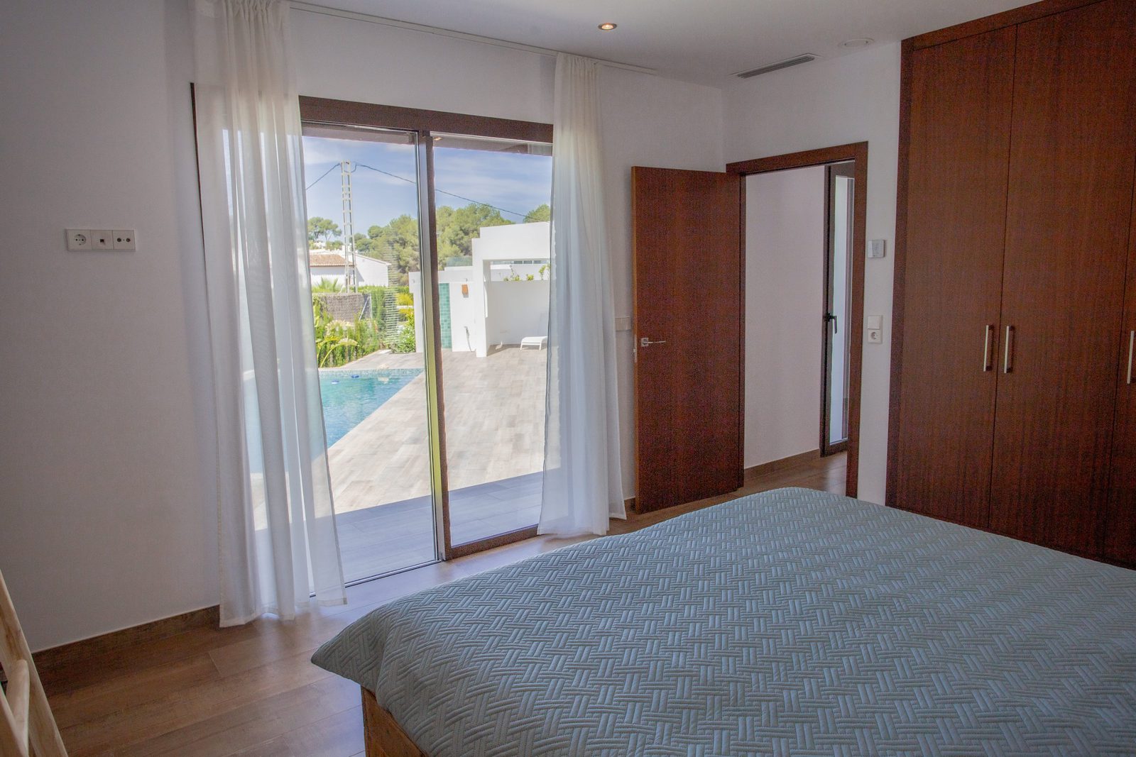 Bedroom with patio doors and garden views in a 3-bedroom villa in Javea - The Estates