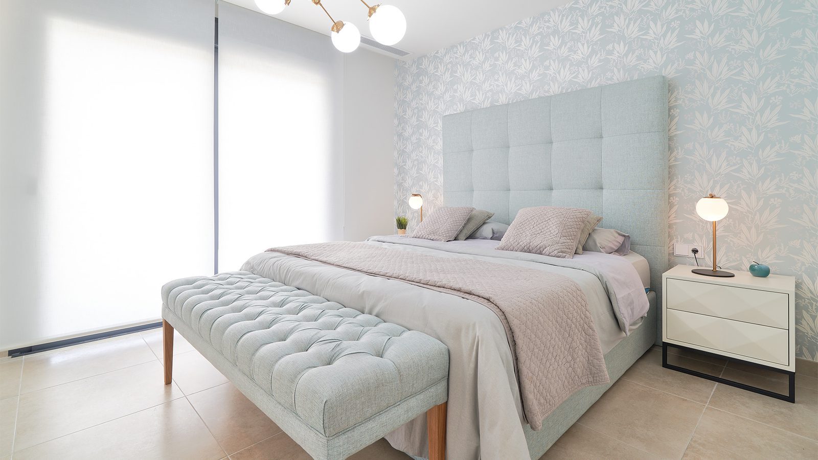 Master bedroom with upholstered bed, bench and botanical wallpaper in a 2-bedroom apartment in Estepona - The Estates