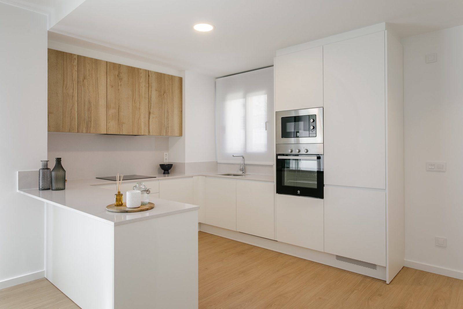 Modern kitchen with sleek white cabinets and wooden accents in a 2-bedroom apartment in Torrevieja - The Estates