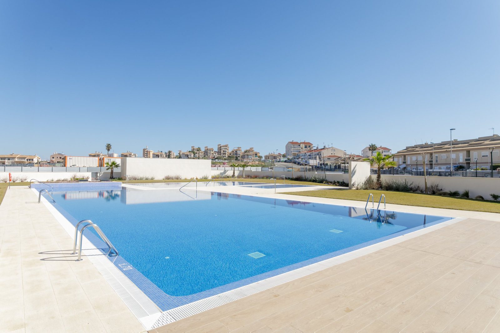 A swimming pool and town views from a 2-bedroom apartment in Torrevieja - The Estates