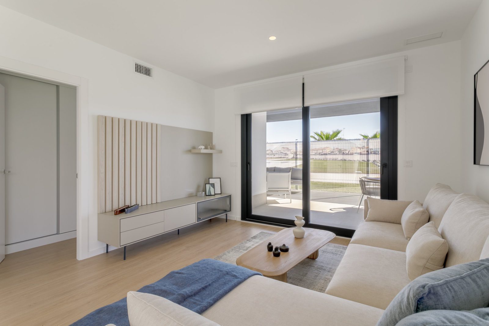 Stylish living room with patio doors and sea views of a 2-bedroom apartment in Torrevieja - The Estates