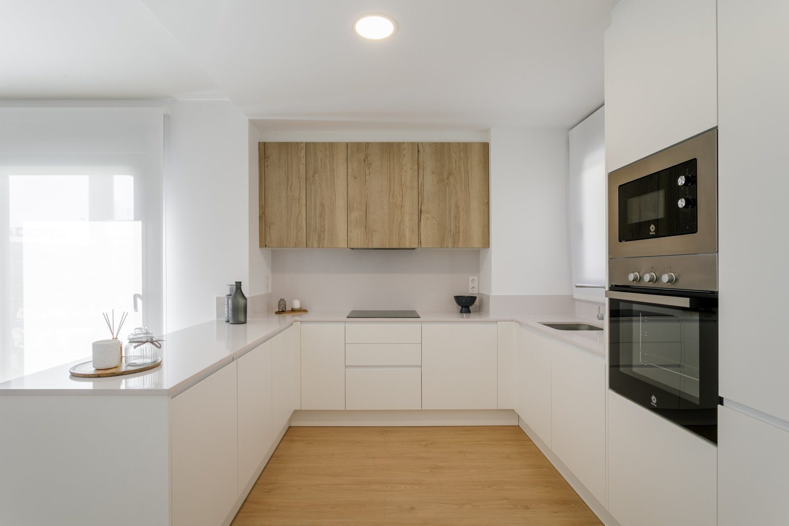 Modern kitchen with white cabinets and wooden accents in a 2-bedroom apartment in Torrevieja - The Estates