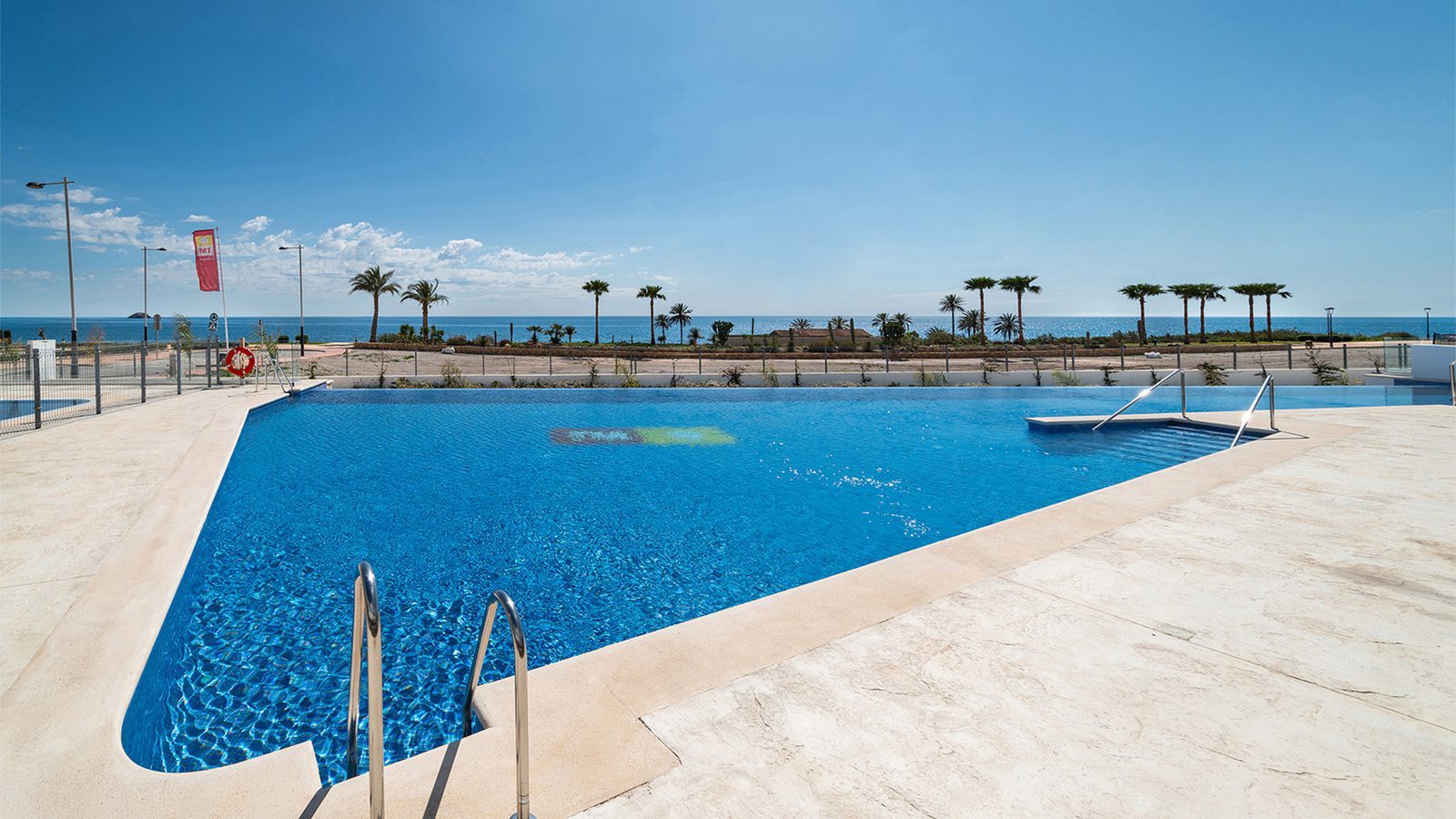 Communal swimming pool with palm trees and sea views of a 3-bedroom bungalow in Pulpí - The Estates