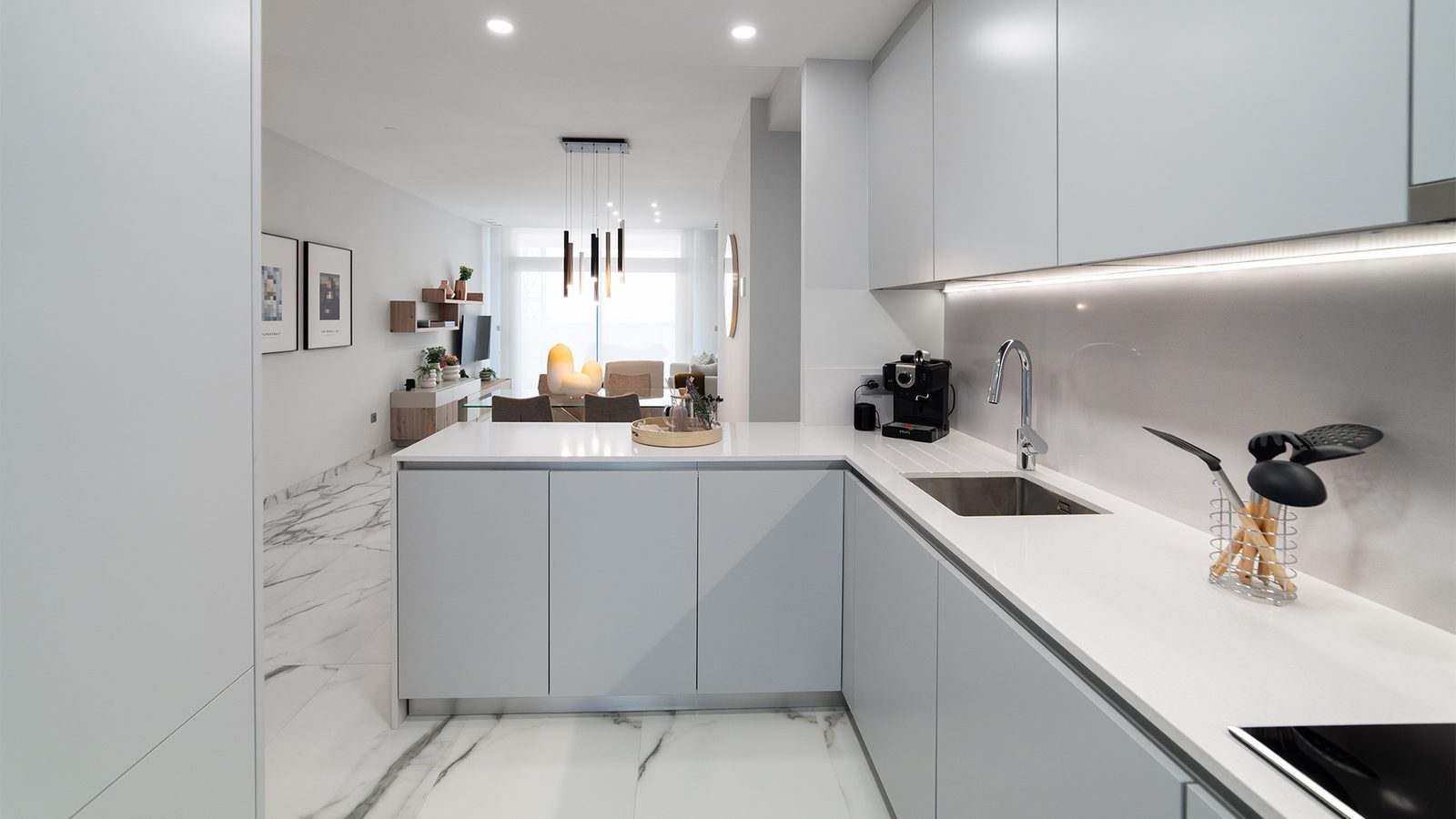 Modern white kitchen and open-plan living area of a 4-bedroom apartment in