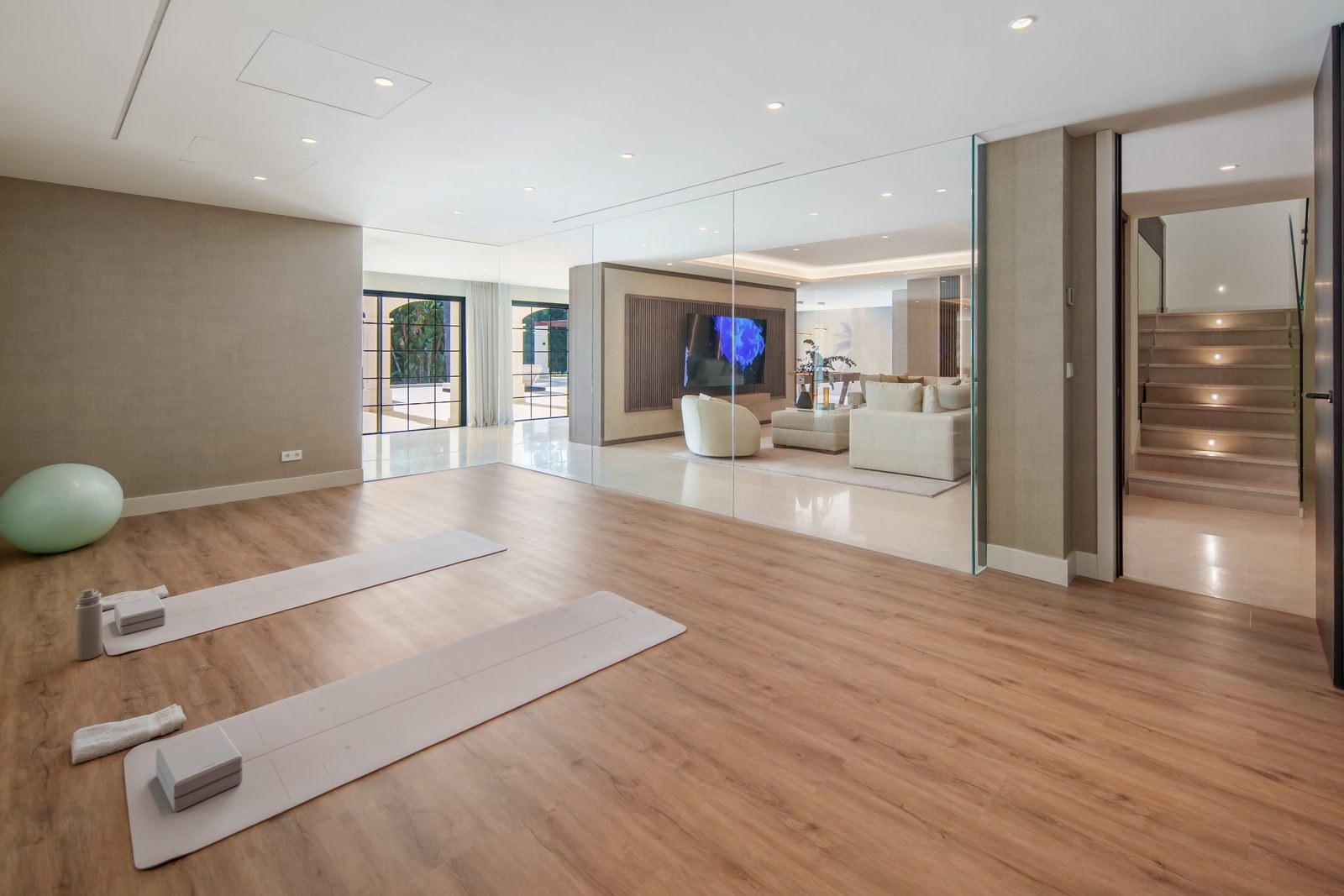 Mirrored yoga and fitness room with mats and exercise ball in a 6