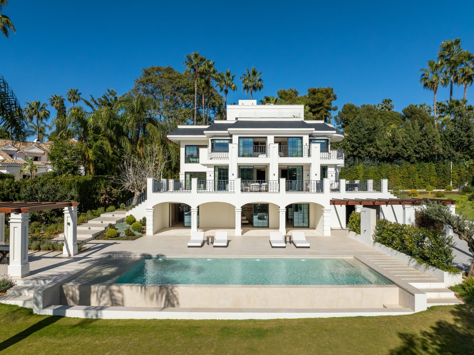 White six-bedroom villa with balconies, landscaped gardens and a swimming pool in Nueva Andalucía, Málaga - The Estates