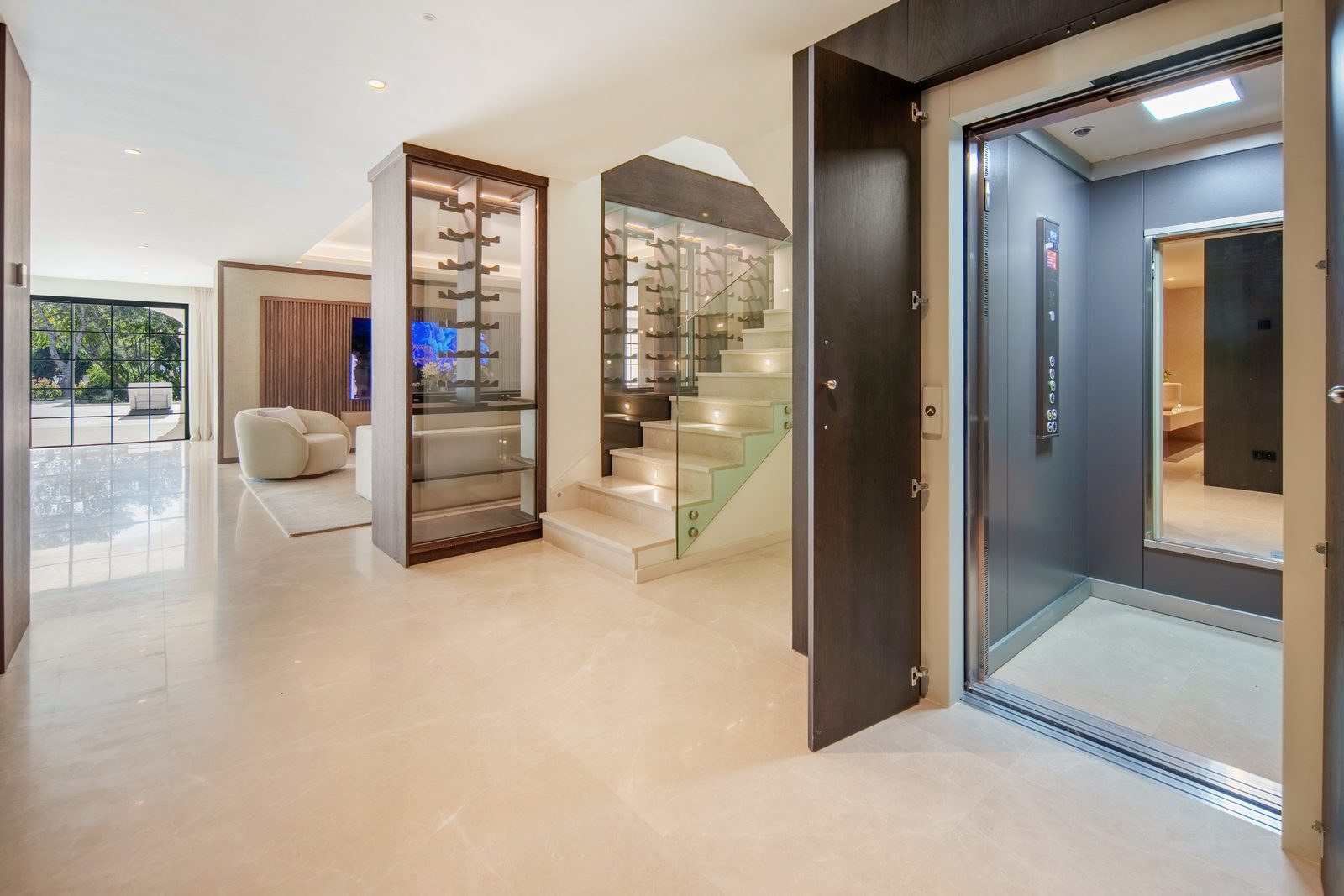 Modern entrance hall with elevator, illuminated staircase and glass wine display of a 6